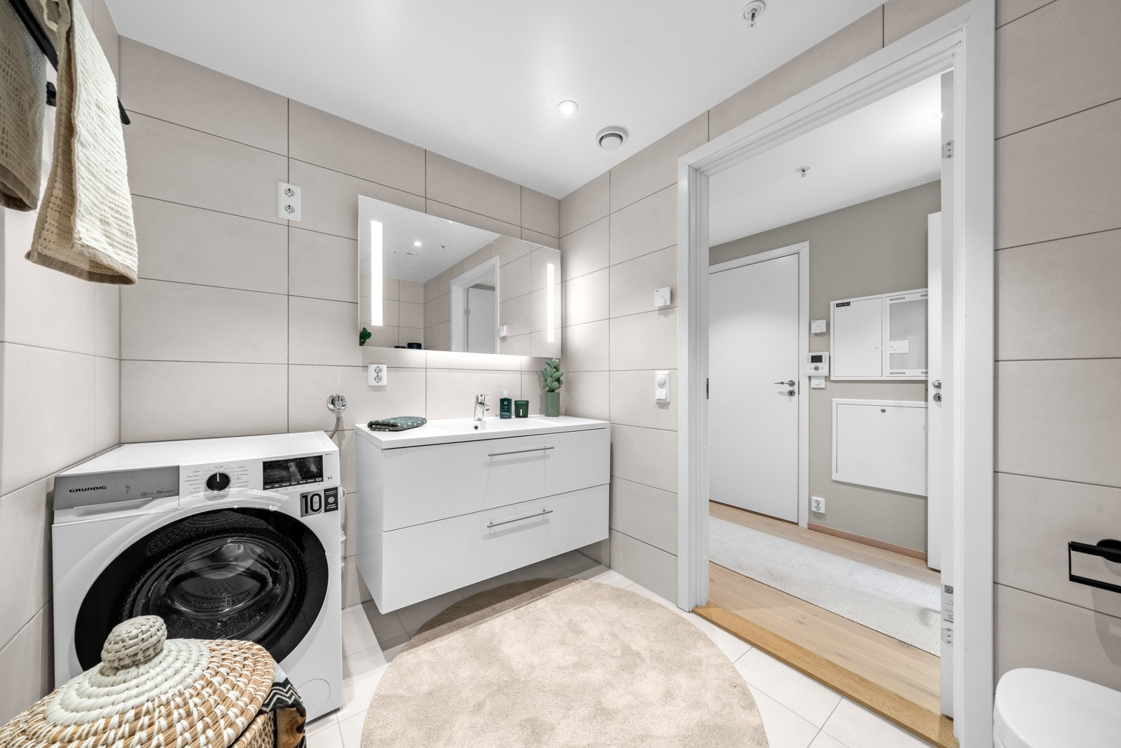 Delikat baderom med gulvvarme og opplegg for vaskemaskin og tørketrommel Galleribilde