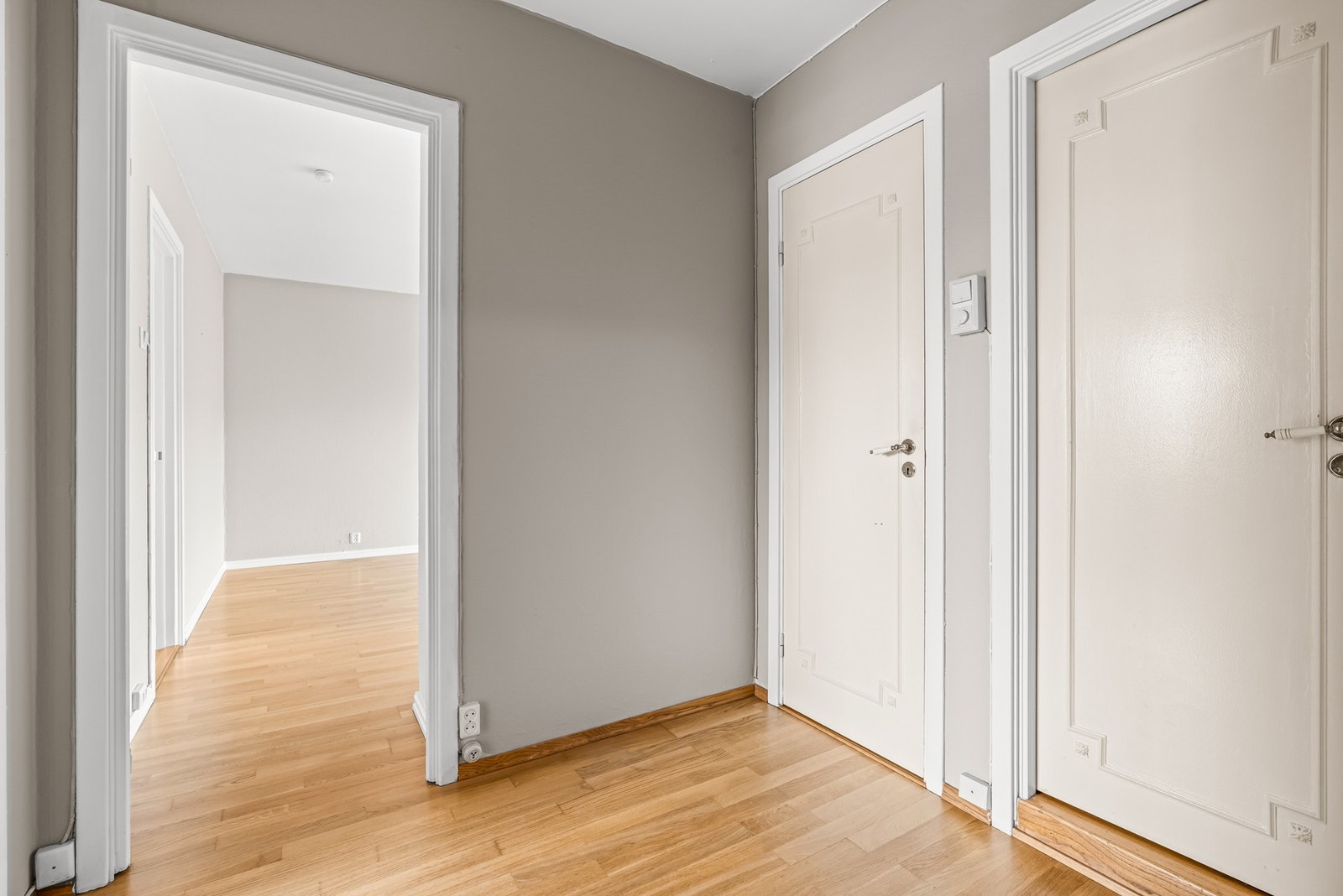 En romslig entré/gang med adkomst til bad, WC-rom, soverom og stue Galleribilde