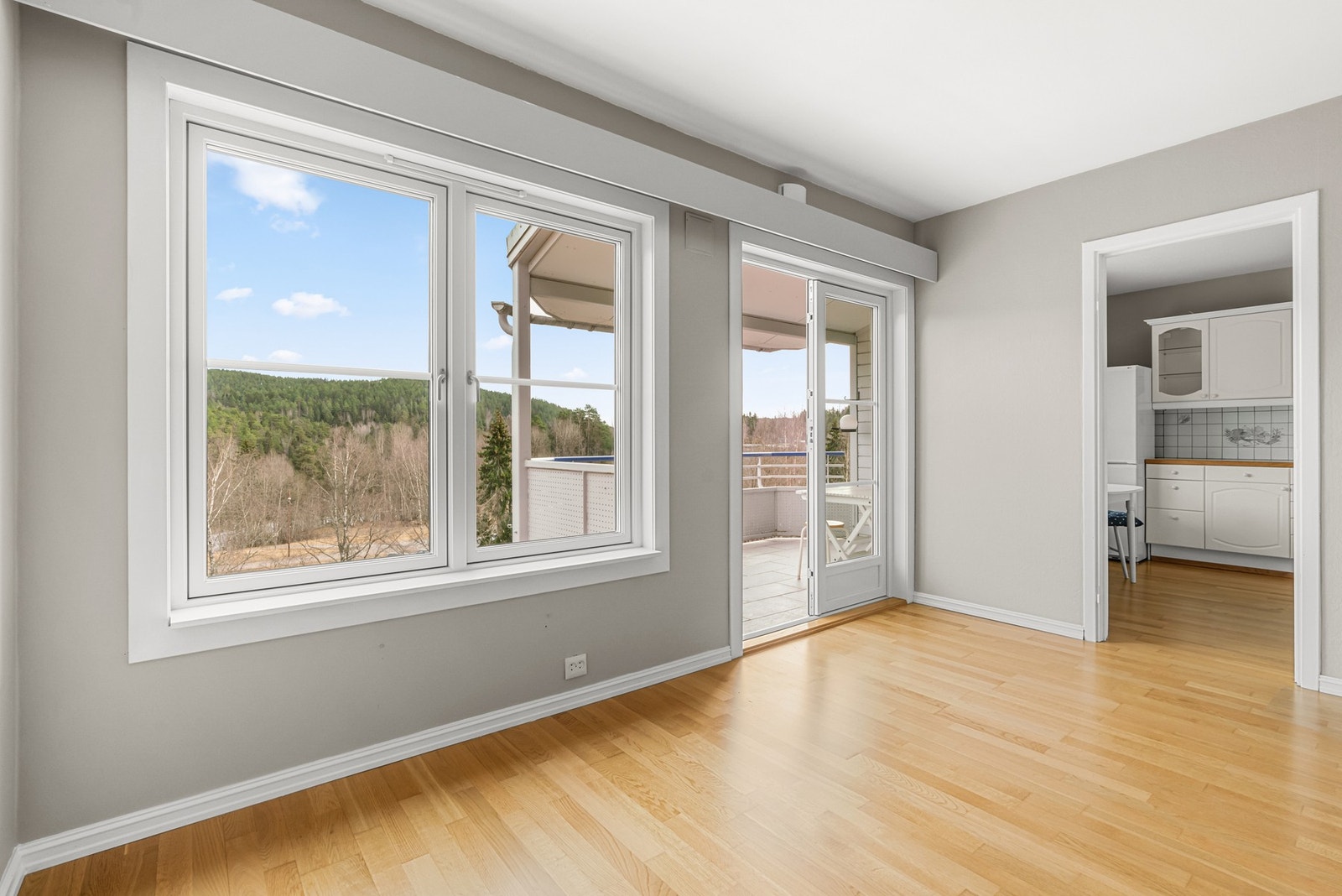 Store vinduer slipper inn rikelig med naturlig lys. Utgang til overbygd balkong, en forlengelse av stuen Galleribilde