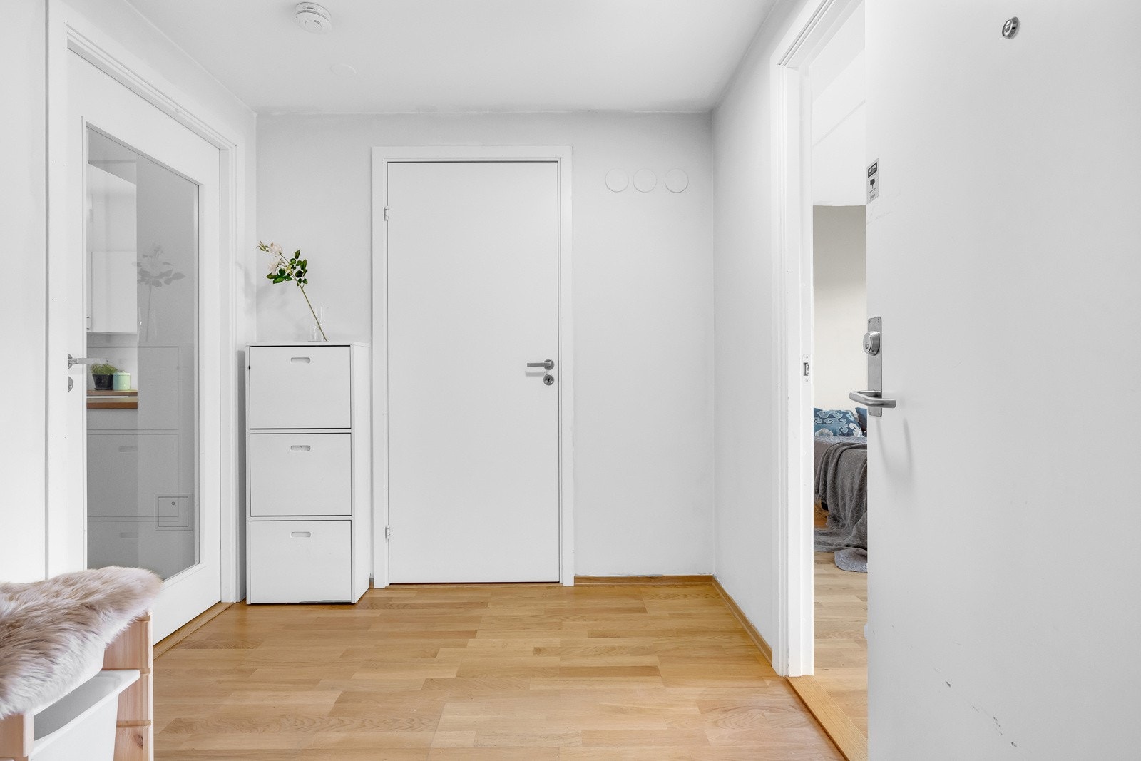 Vel inne blir man ønsket velkommen i en pen entré med hvitmalte vegger og gyllent parkettgulv. Her er det god plass til garderobe og andre oppbevaringsløsninger. Galleribilde