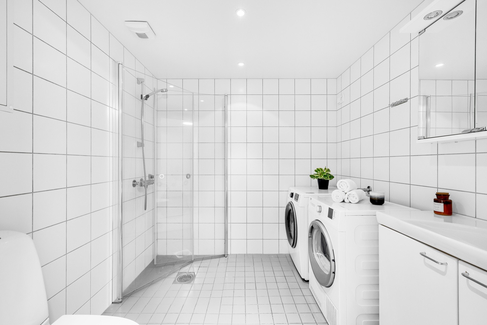 Leiligheten har et romslig og delikat bad med hvite fliser på veggene, downlights i himlingen og lysegrå fliser på gulv med gulvvarme. Galleribilde