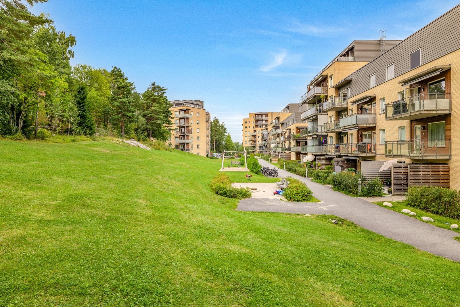 Bygningen omkranses av velholdte fellesarealer, bestående av asfalterte internveier og store gressplener beplantet med prydbusker. Galleribilde