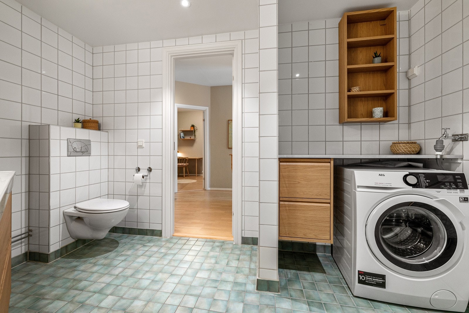 Flislagt baderom med vannbåren varme i gulv og opplegg for vaskemaskin. Galleribilde