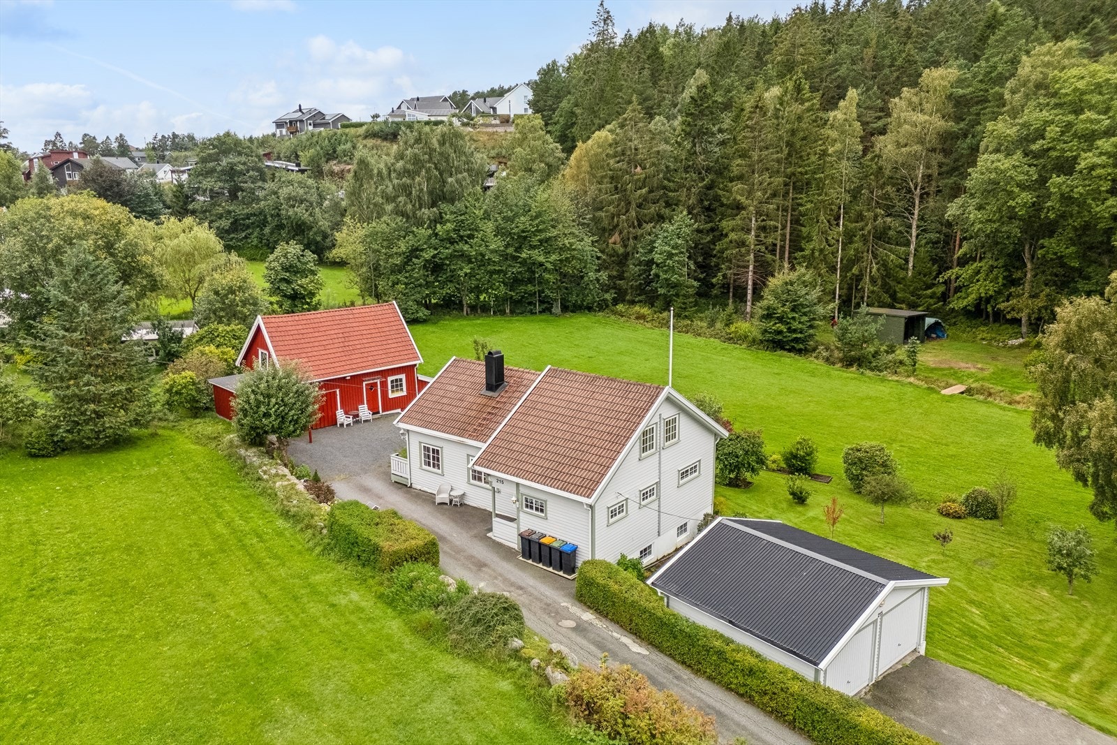 Eiendommen har en romslig tomt med enebolig, garasje, uthus og lekestue. Galleribilde