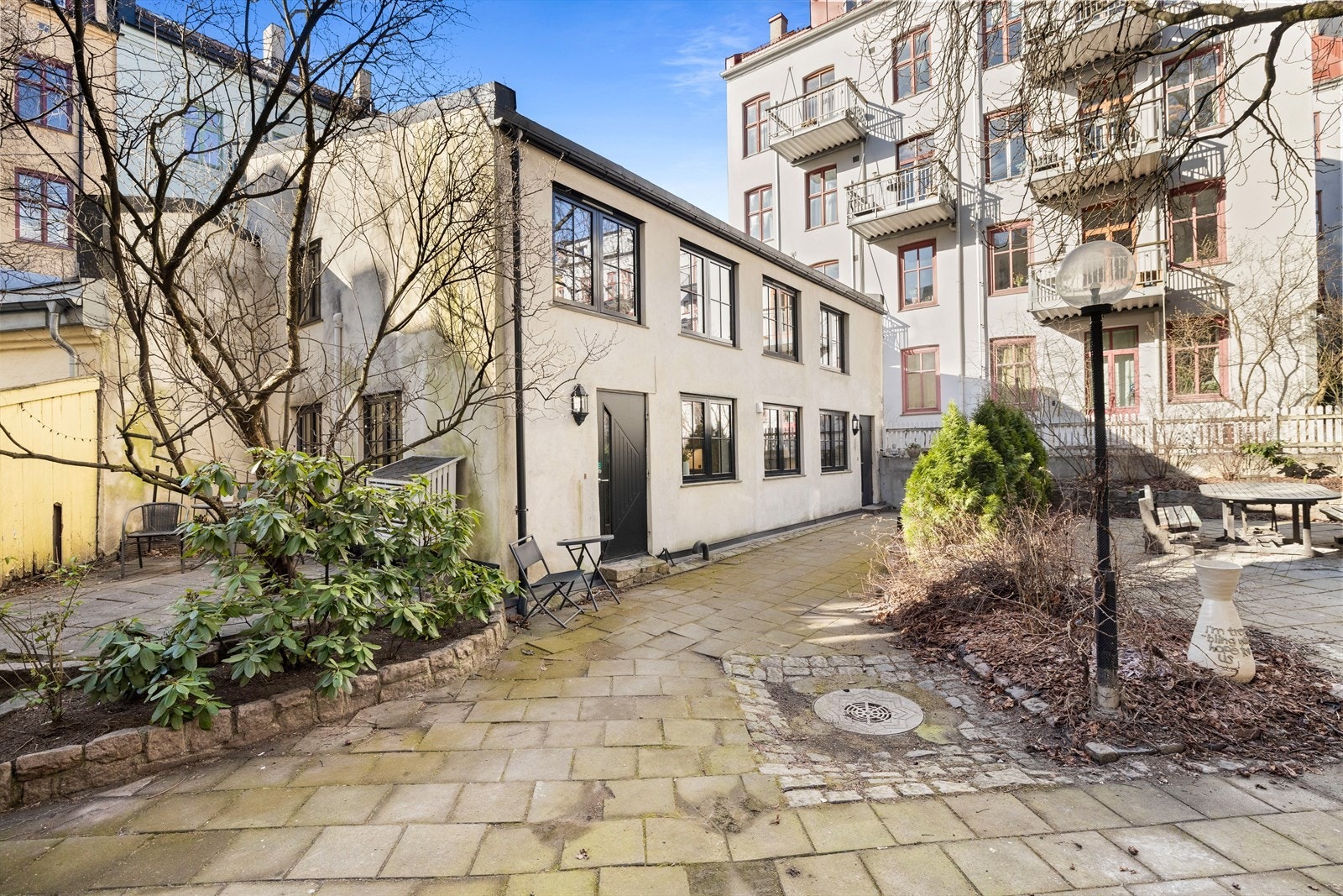 Idyllisk bakgård pent opparbeidet med brostein og beplantning. Galleribilde