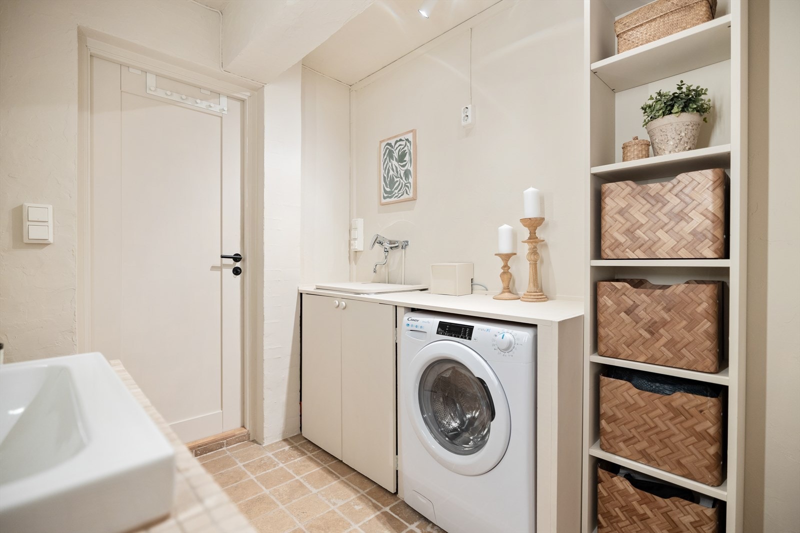 Baderomsinnredning med skap, servant og vegghengt speilskap. Det er utslagsvask og vaskemaskin (medfølger). Badet er innredet med vegghengt toalett og romslig dusjhjørne. Galleribilde