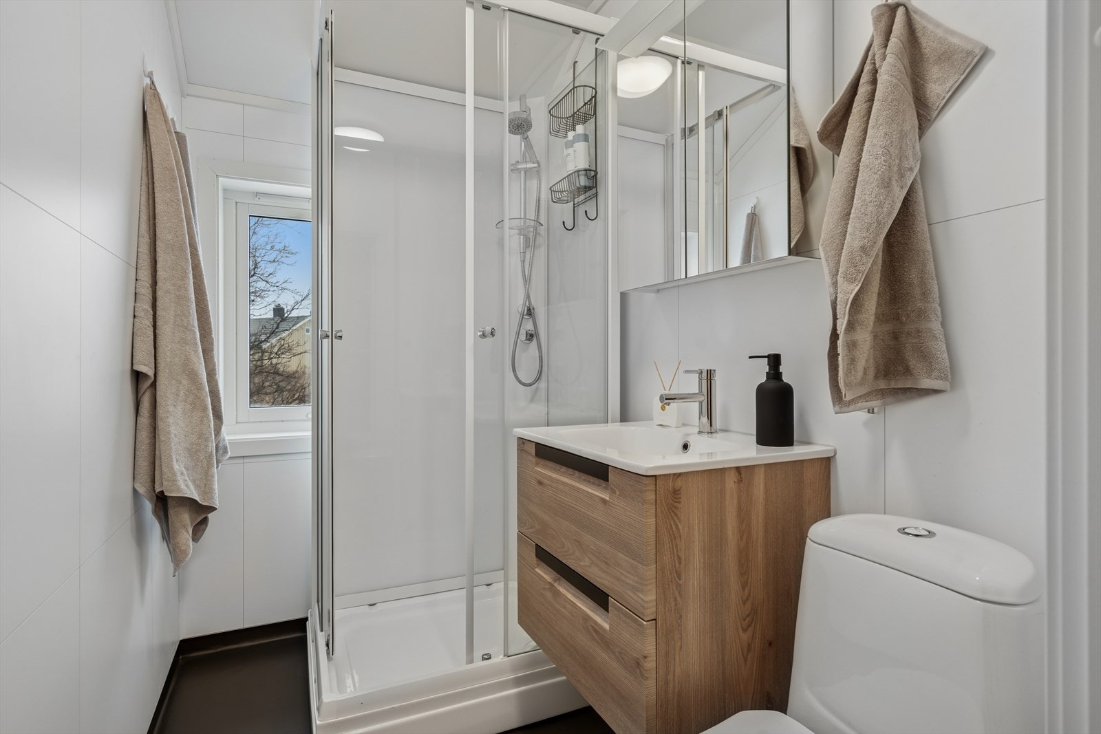 Her finner du toalett, dusjkabinett og baderomsinnredning - Innredningen består av servant med to skuffer under og overskap med speilfronter Galleribilde