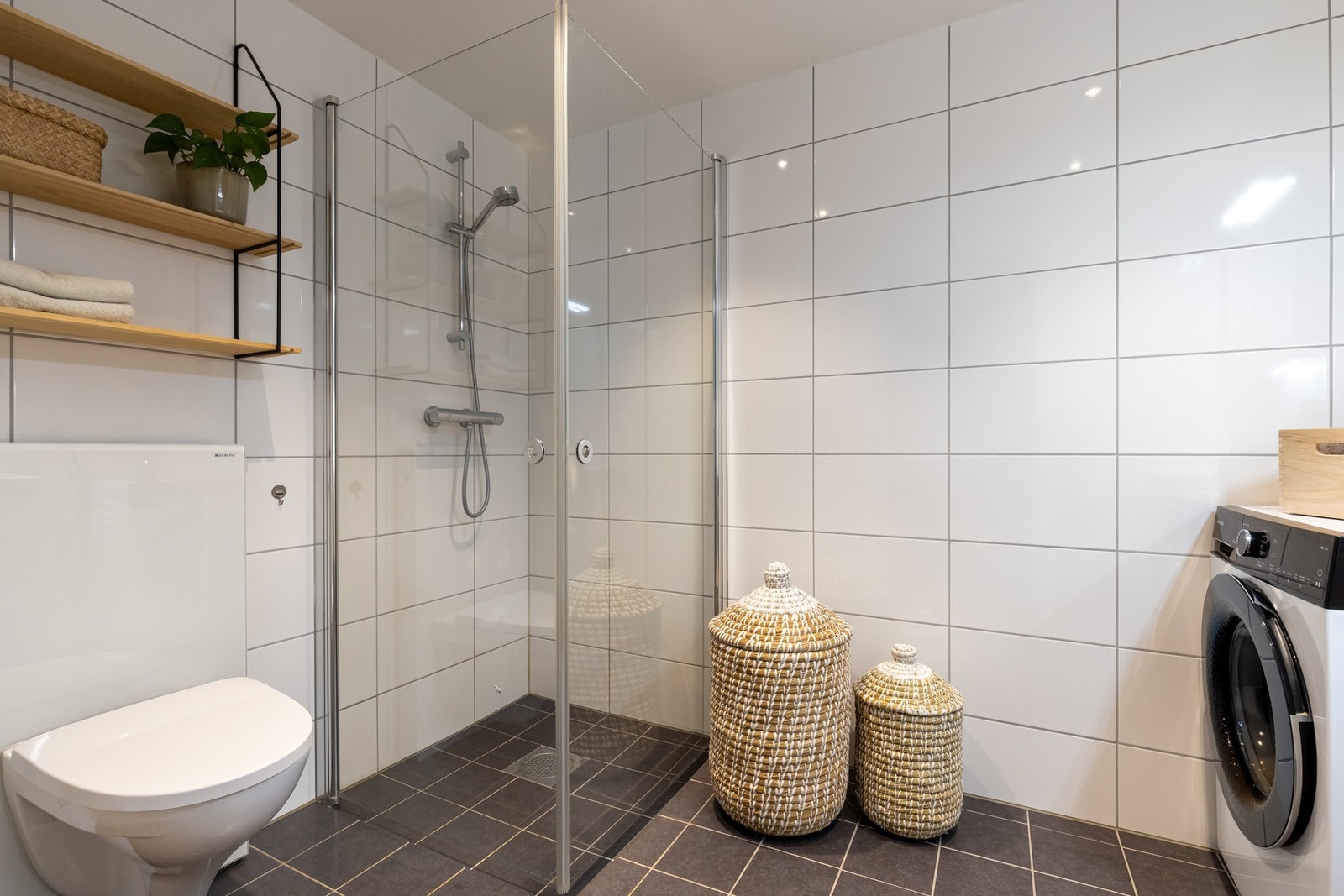 Videre er det dusjhjørne med svingbare dører som frigjør plass på gulvet og opplegg for vaskemaskin. Er det behov for tørketrommel vil det være plass til dette også. Galleribilde