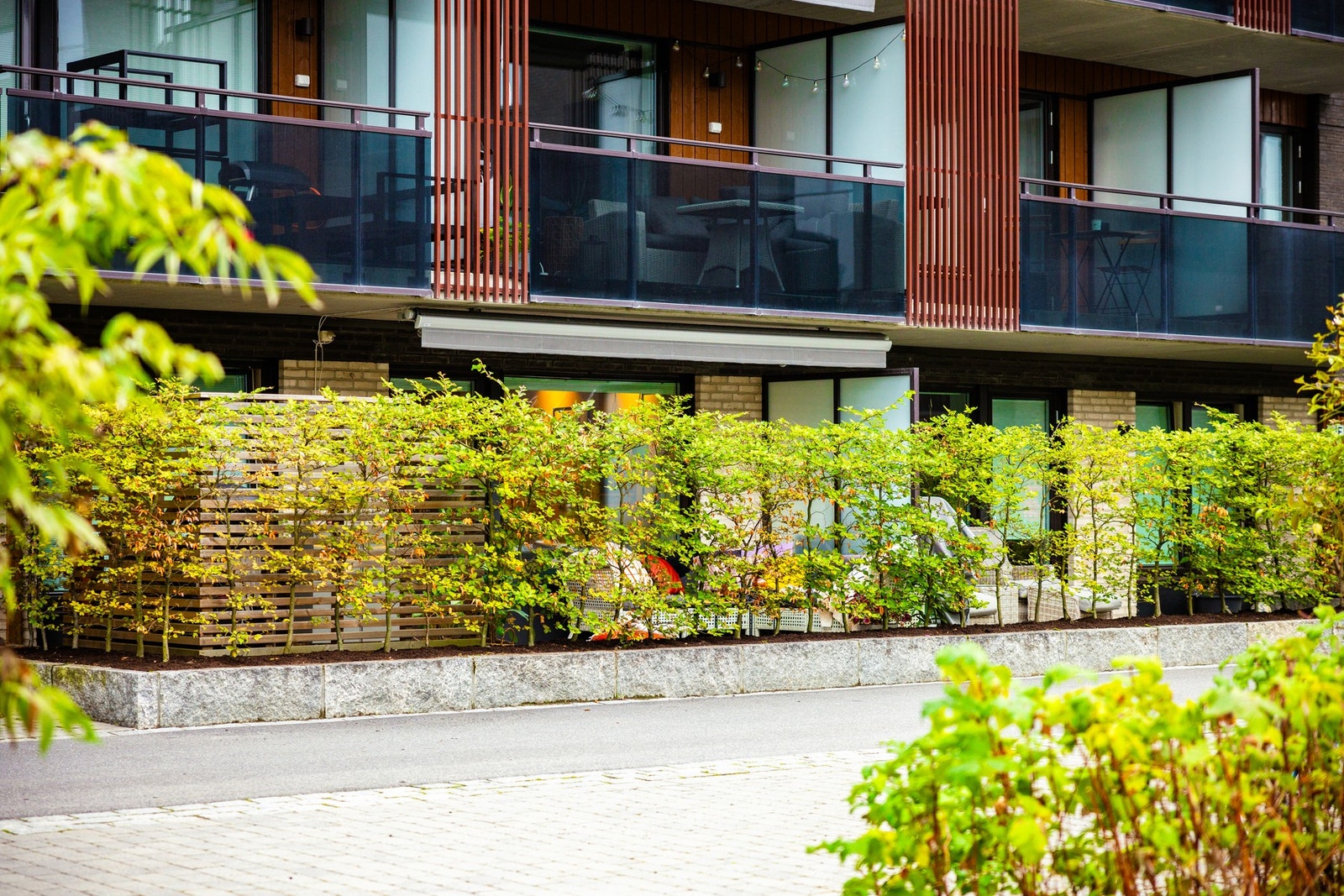 Leveggene på begge sider kombinert med buskene gjør at uteplassen oppleves mer skjermet. Galleribilde