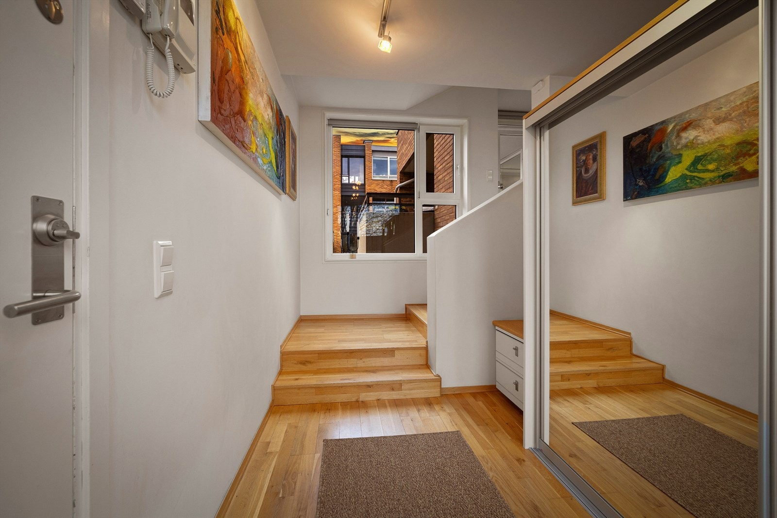 Entréen gir et innbydende førsteinntrykk med romslig skyvedørsgarderobe med speildører. Galleribilde