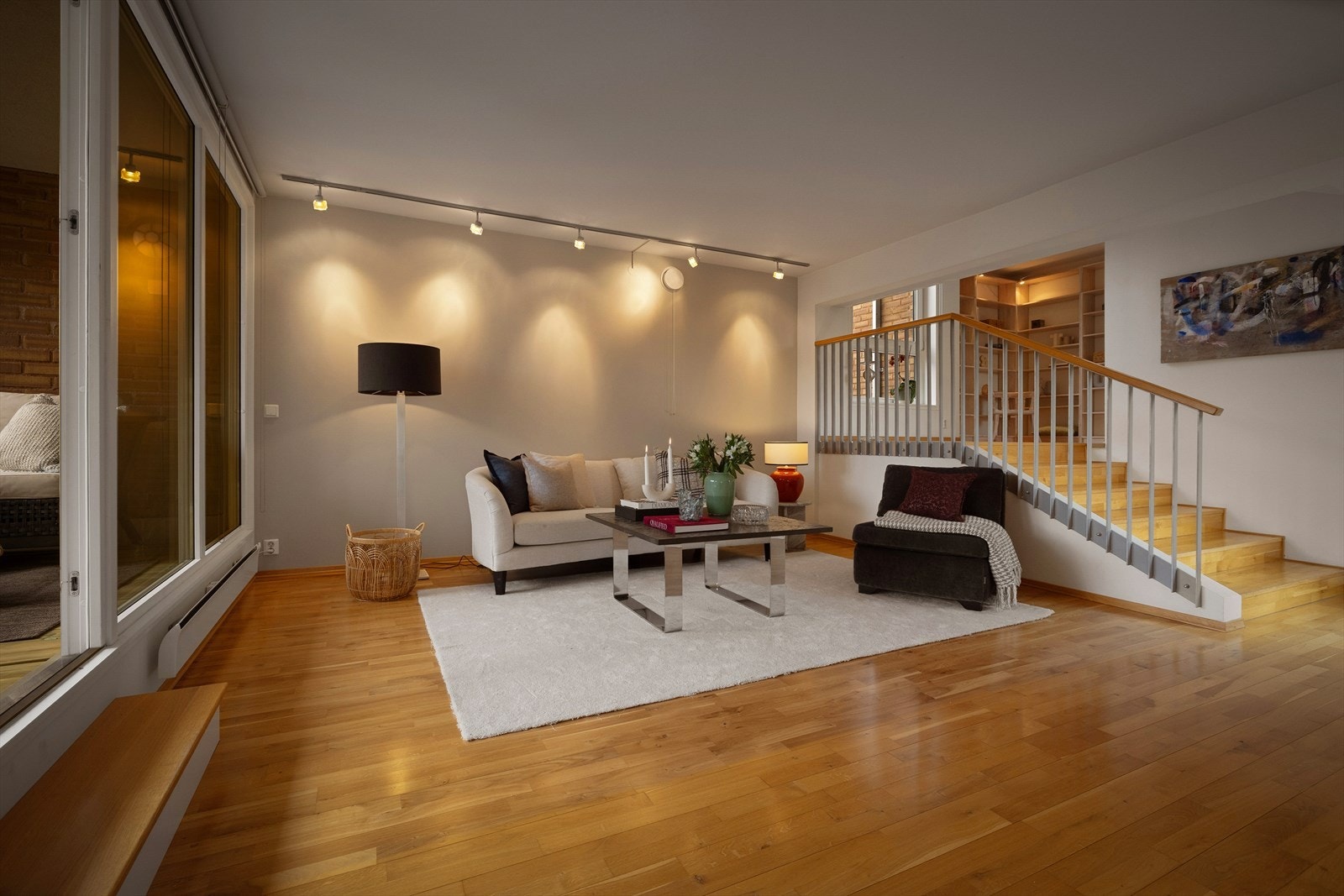 Den romslige stuen har store vindusflater fra gulv til tak, som slipper inn rikelig med naturlig lys og skaper en luftig atmosfære. Galleribilde