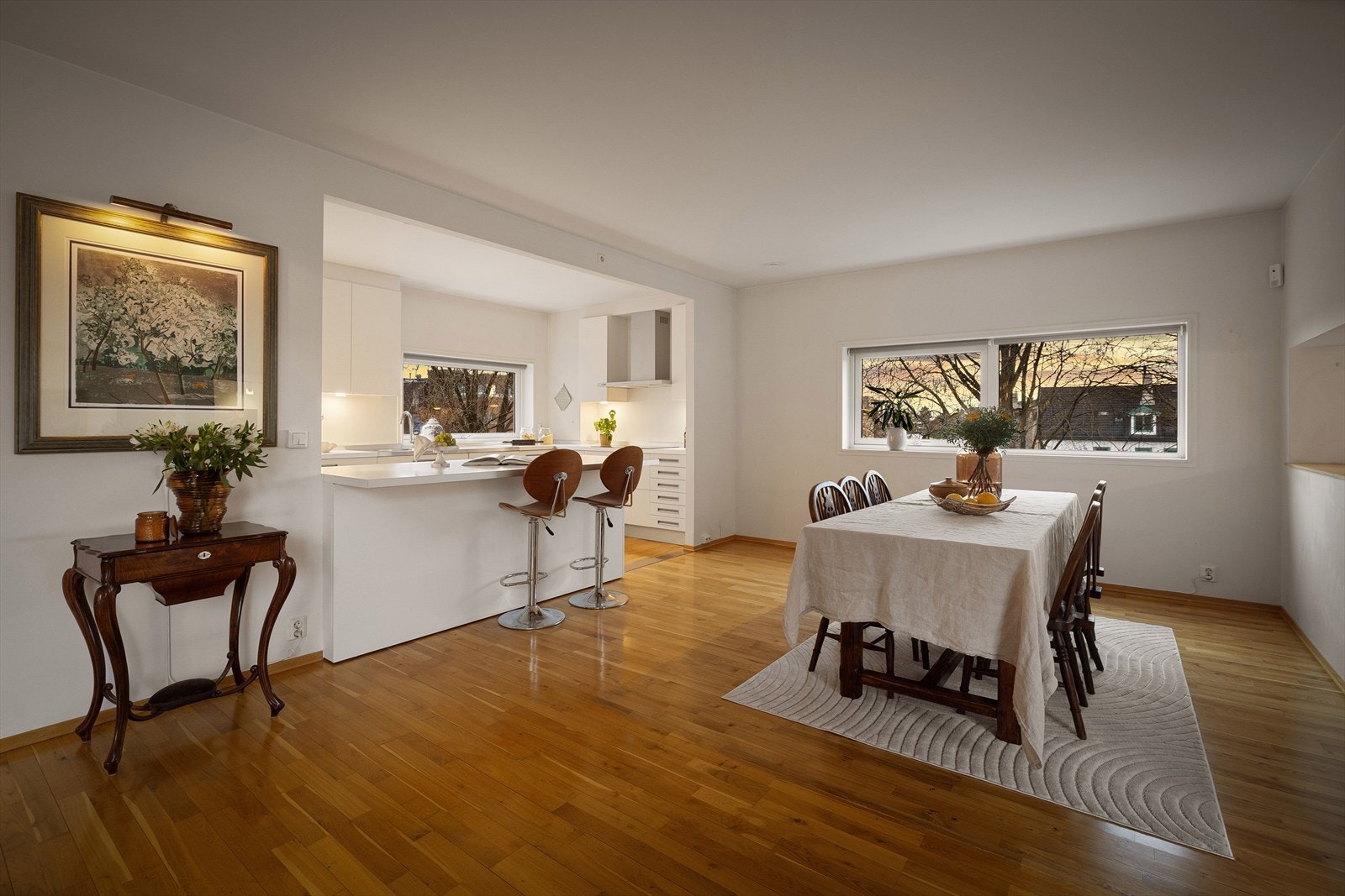 Kjøkkenet har en funksjonell U-løsning med en kjøkkenøy som skaper en naturlig romdeling mot spisestuen. Galleribilde