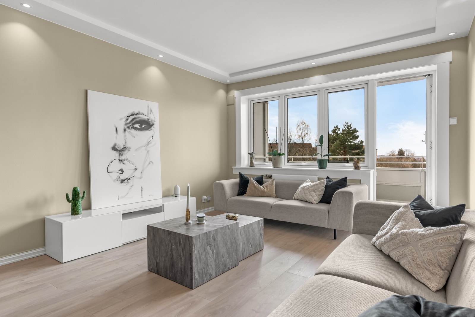 Stuens overflater holder en tidsriktig og moderne standard med pene overflater i gulv, vegger og tak, samt downlightsbelysning i tak. Galleribilde