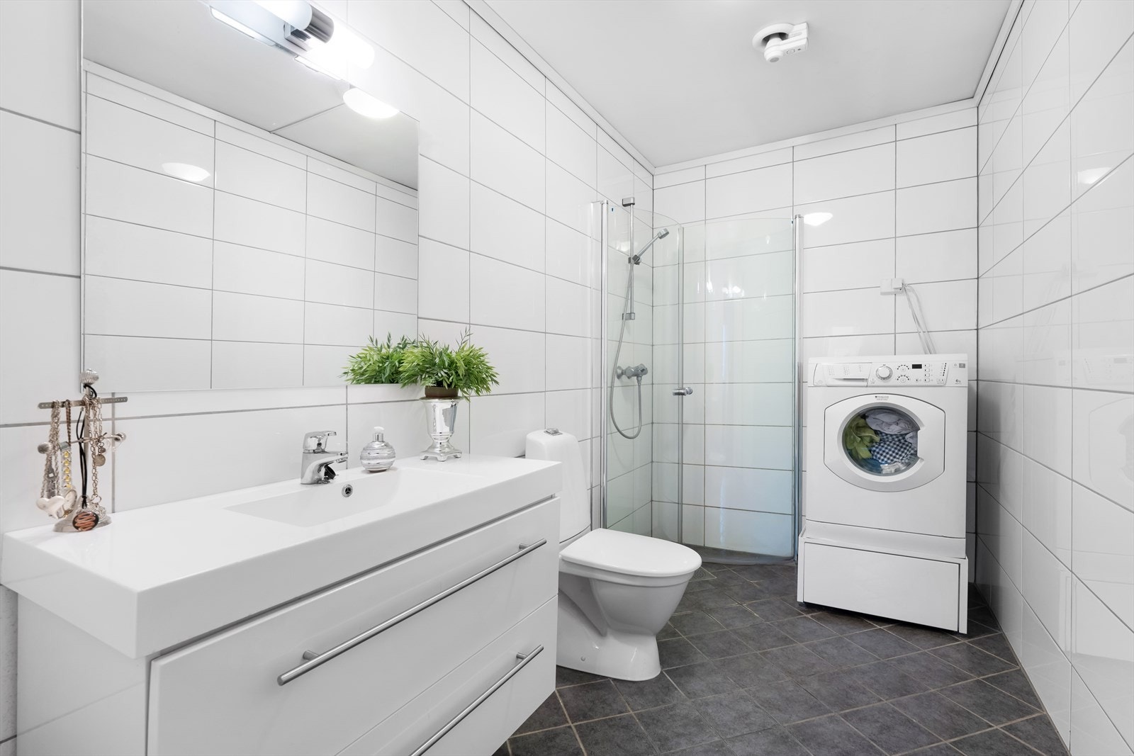 Badet er utstyrt med dusjhjørne, toalett, servant og opplegg til vaskemaskin. Galleribilde