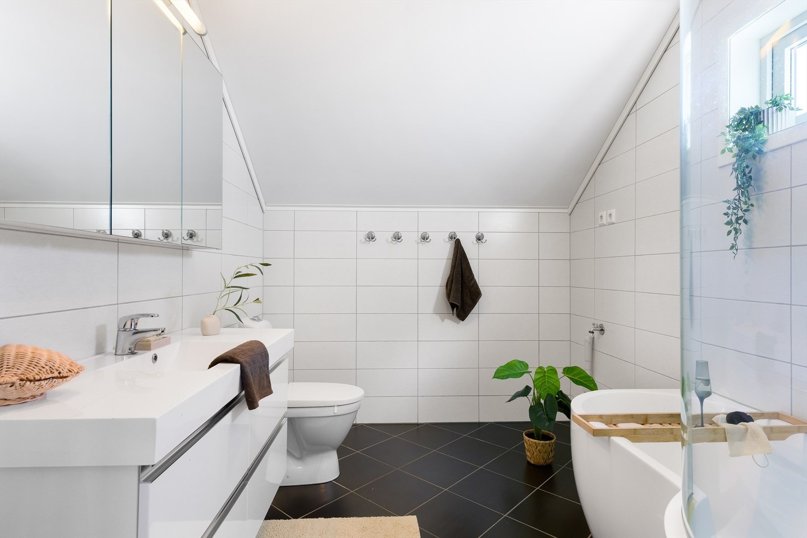 Badet er utstyrt med badekar, toalett og servant med overskap/speil. Galleribilde