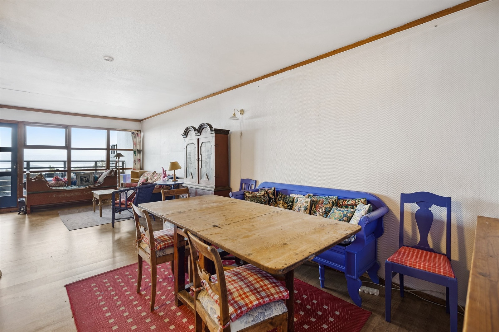 Lys og romslig stue med spisestue i en åpen løsning, kombinert med et delvis åpent kjøkken. Galleribilde