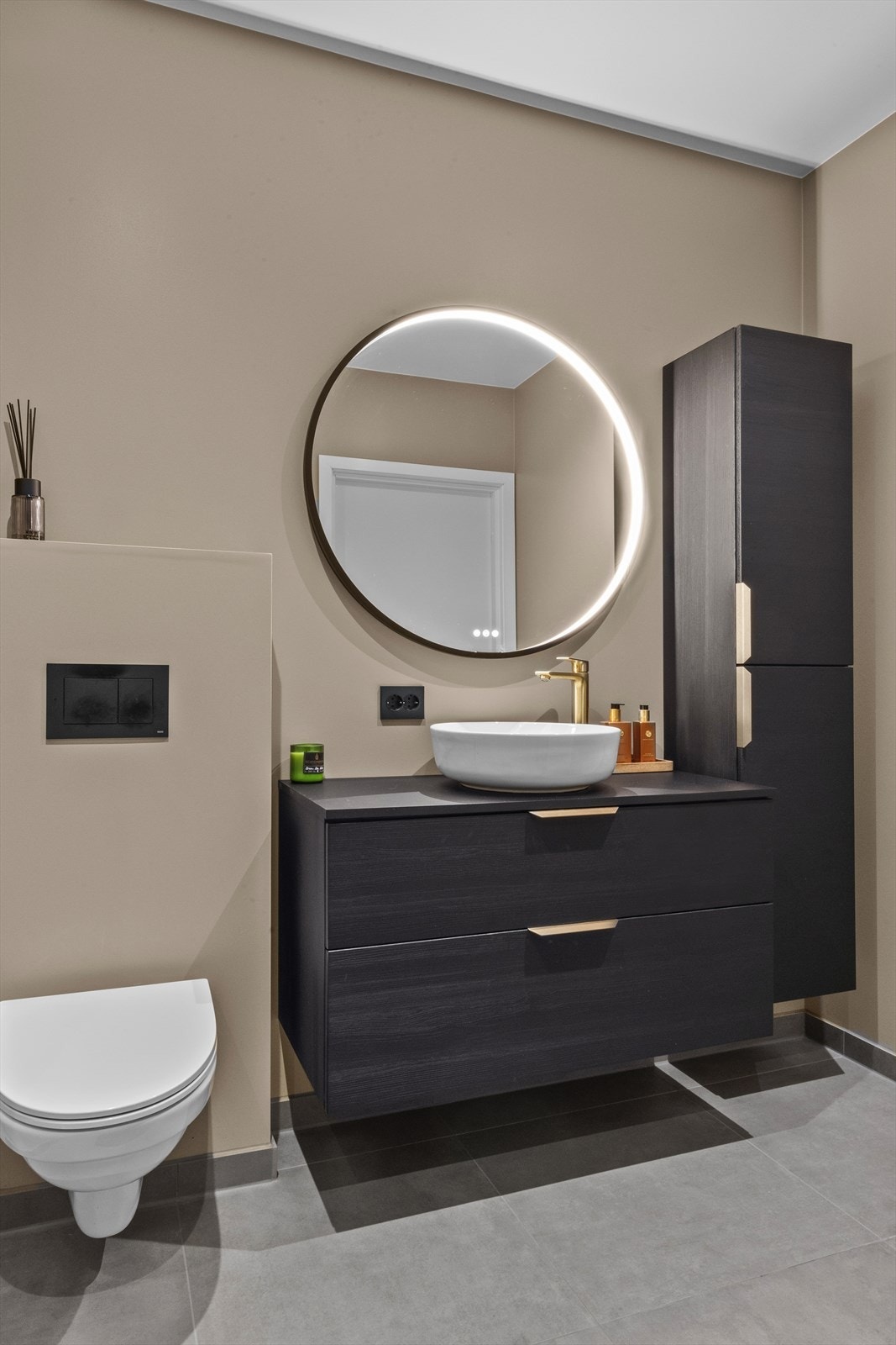 Flott baderom med rundt speil med lys. Galleribilde