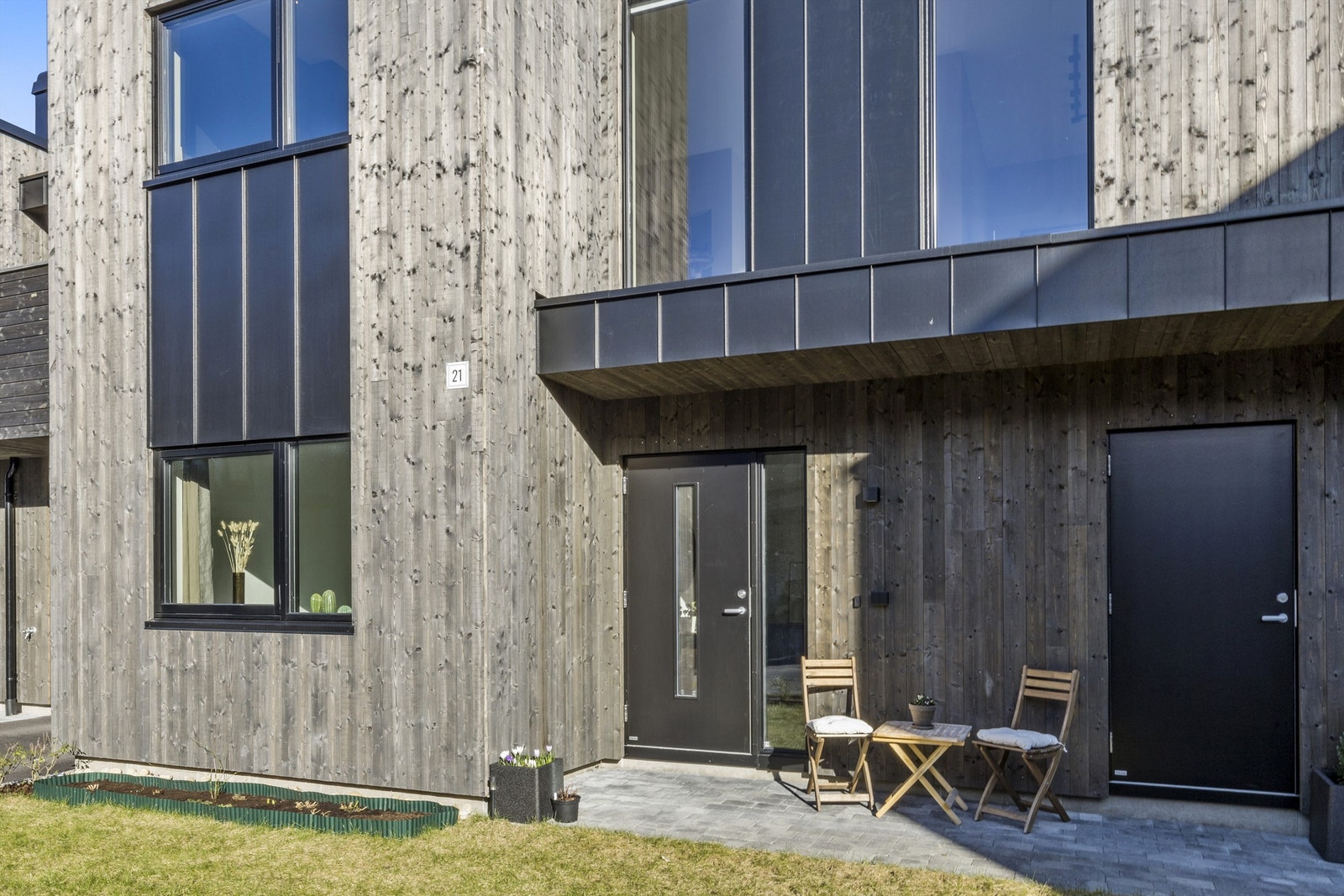 Ved inngangspartiet kan ettermiddagssolen nytes mens barna leker i hagen. Galleribilde