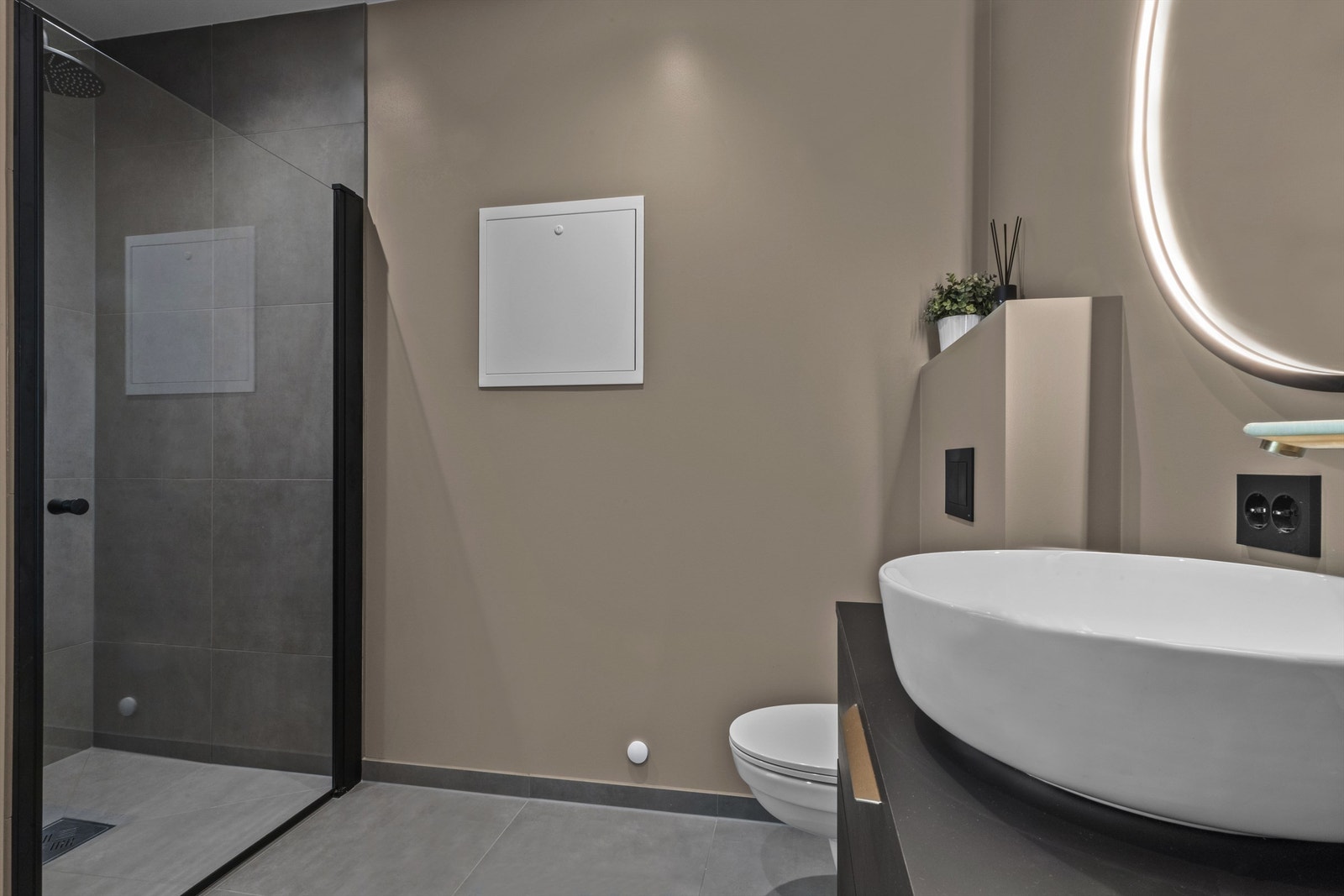 Romslig, flislagt dusjsone med glassdør. Galleribilde