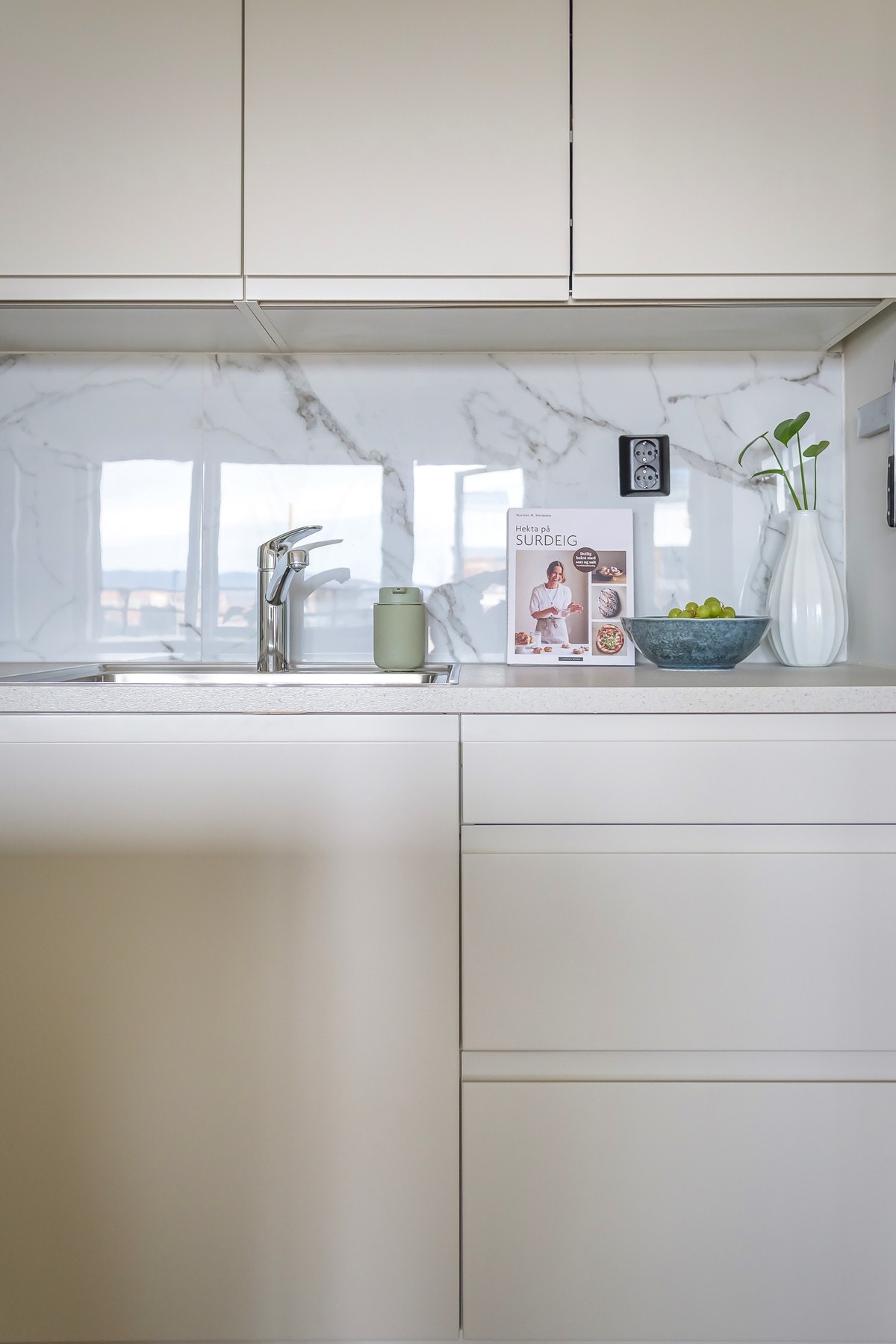 Fliser over benk og integrert kjøkkenkum gir et helhetlig og stilrent uttrykk. Galleribilde