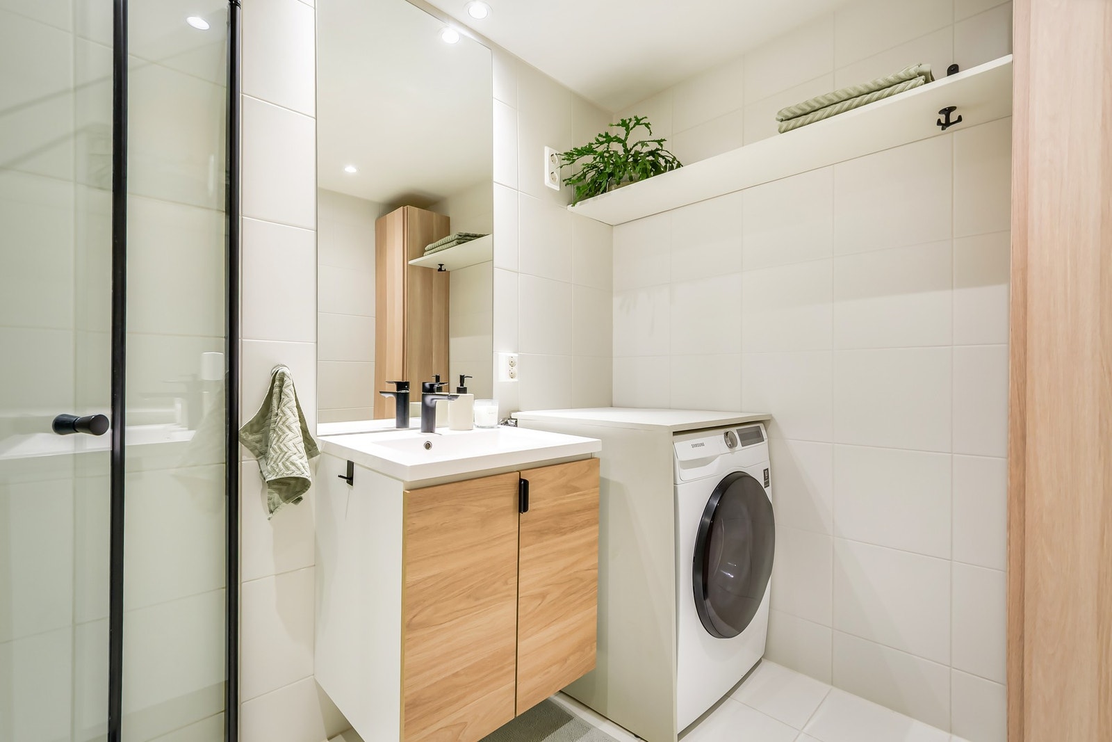 Praktisk løsning med opplegg for vaskemaskin, god oppbevaring og helhetlig design. Galleribilde