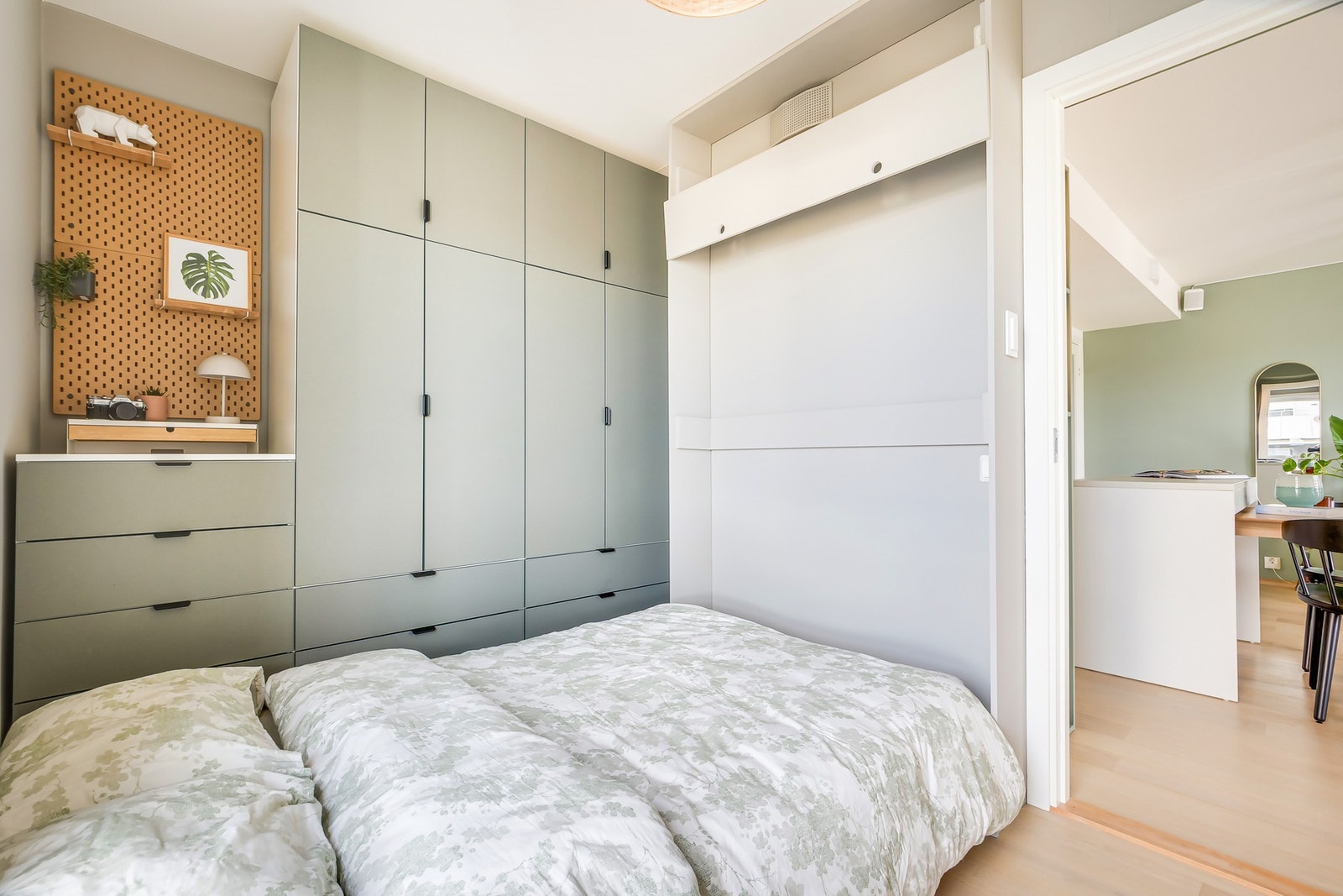 Smart og plassbesparende soverom med nedtrekkbar seng og integrerte garderobeskap i helhetlig design. Galleribilde