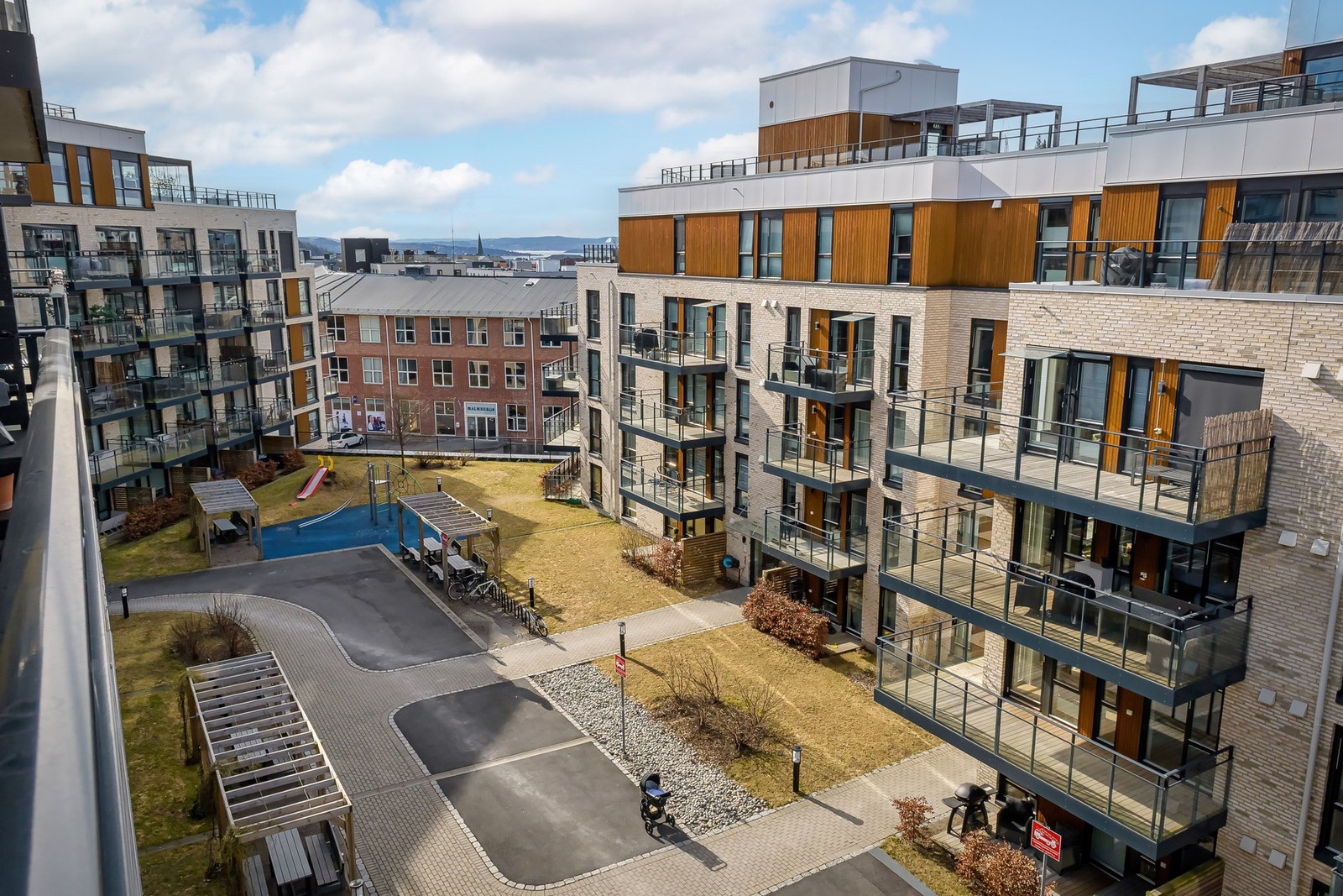 Utsyn fra balkong mot borettslagets fellesarealer. Galleribilde