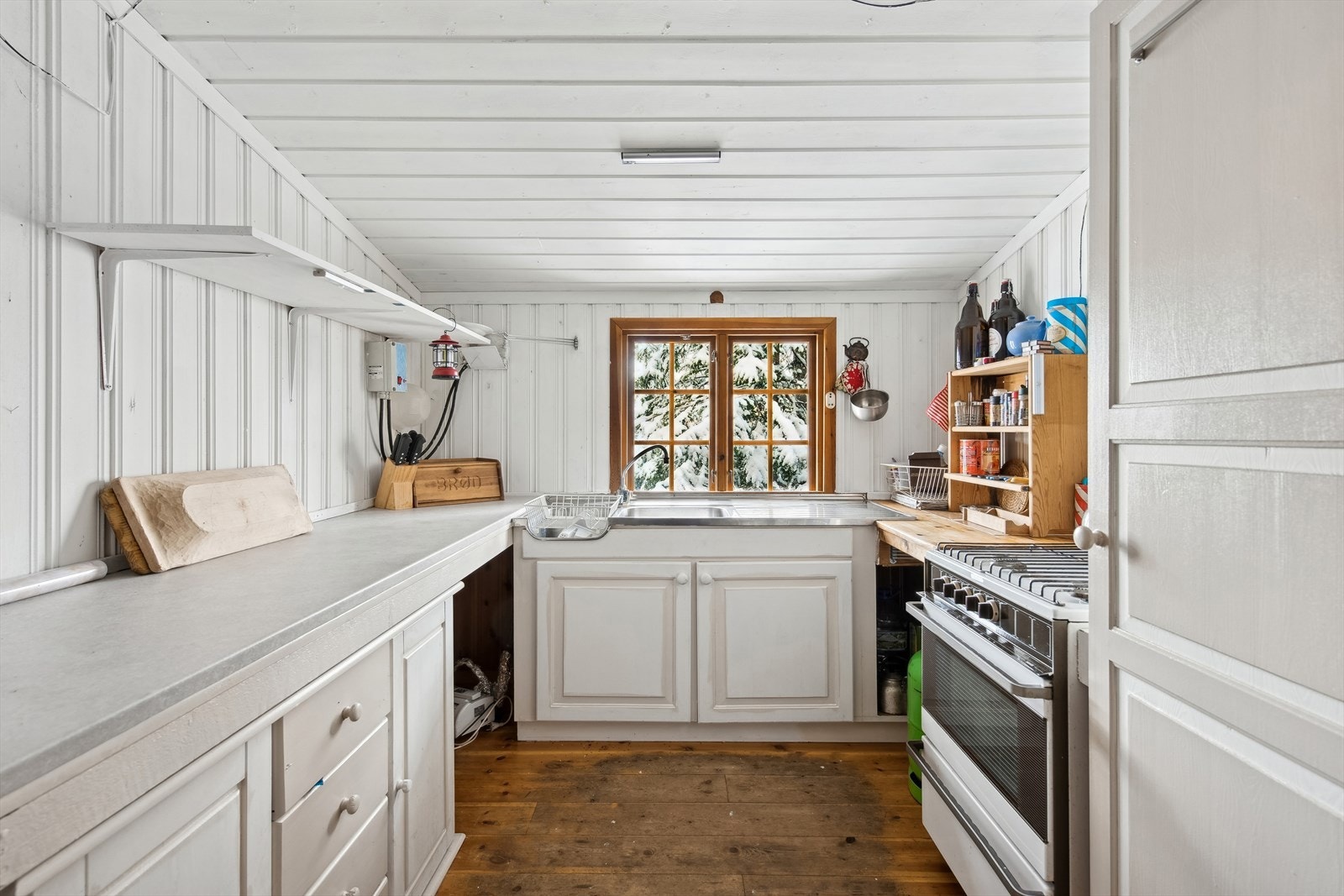 Kjøkken med gasskomfyr med platetopp og kjøleskap. Galleribilde