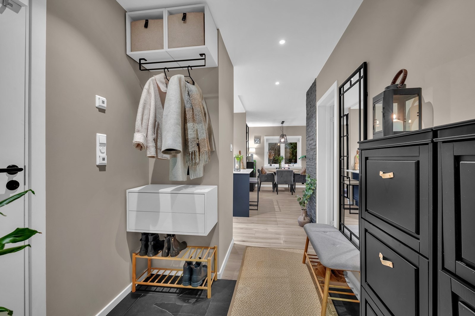 Boligen har en innbydende entré med downlights i himlingen og fliser på gulvet med gulvvarme, som gir et varmt og velkomment førsteinntrykk. Det stilfulle designet setter tonen for resten av boligen, og skaper en lys og trivelig atmosfære fra første steg. Galleribilde