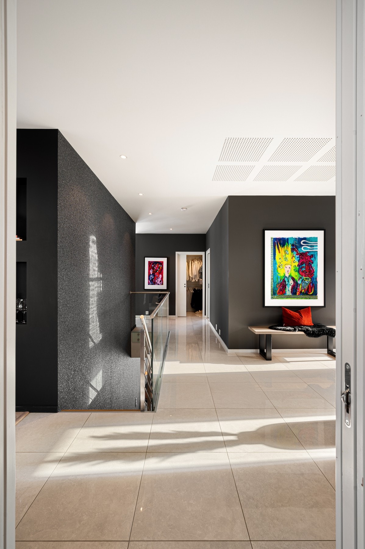 Stor og romslig gang med trapp og lekker "steinpreget" vegg ned til kjellerstue Galleribilde