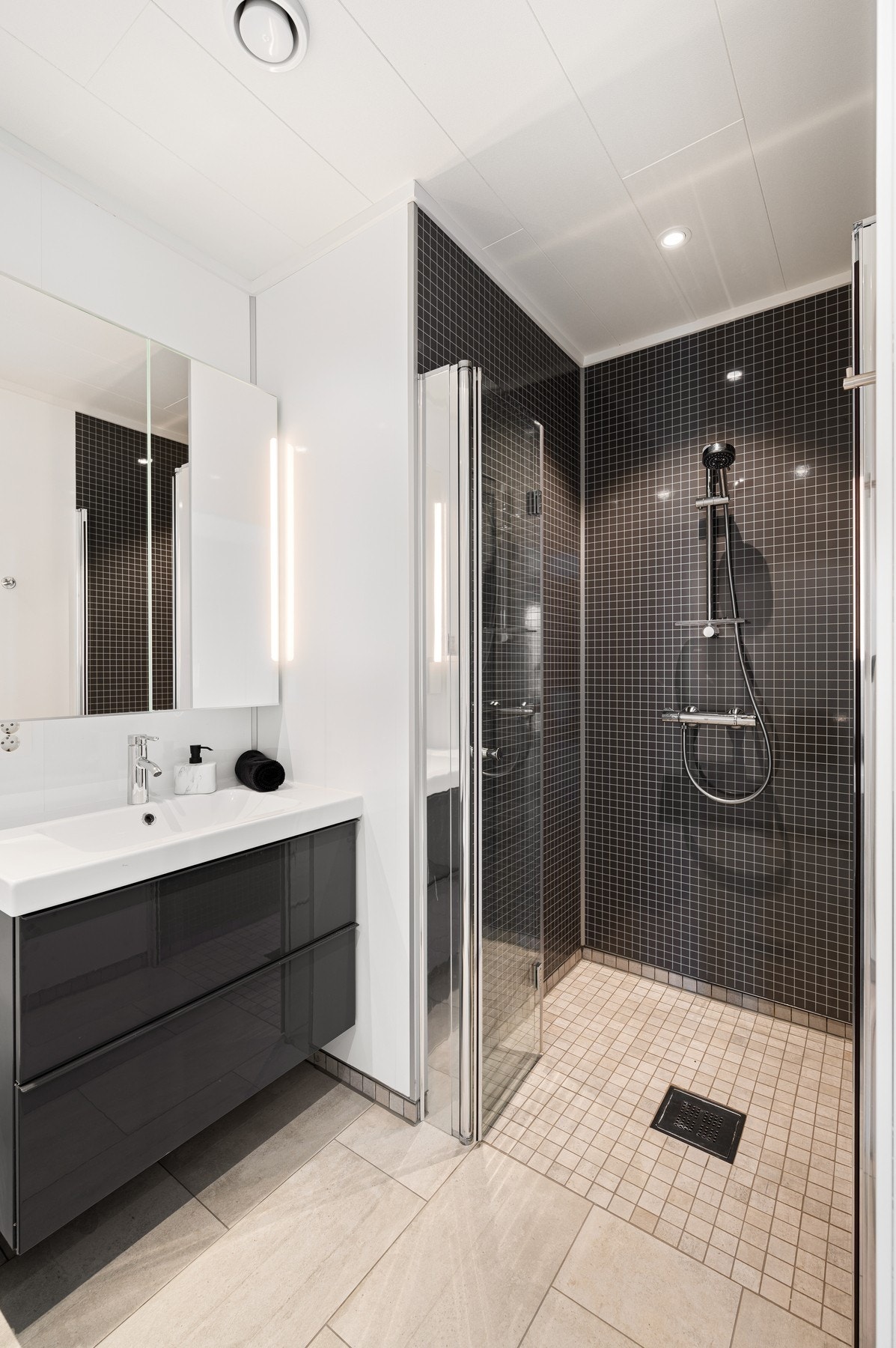 I tillegg til servantinnredning og toalett, er det dusjhjørne med glassdører. Baderomsplater i dusjsonen er skiftet ut etter at bildet er tatt på grunn av skade på en av platene. Galleribilde