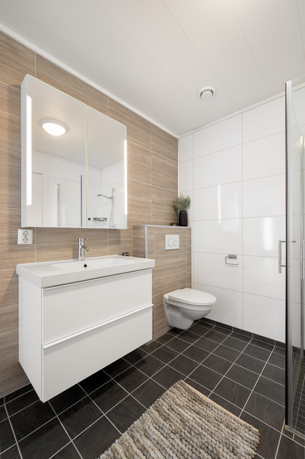 Badet er romslig og pent og inneholder servantinnredning, toalett og dusjhjørne Galleribilde