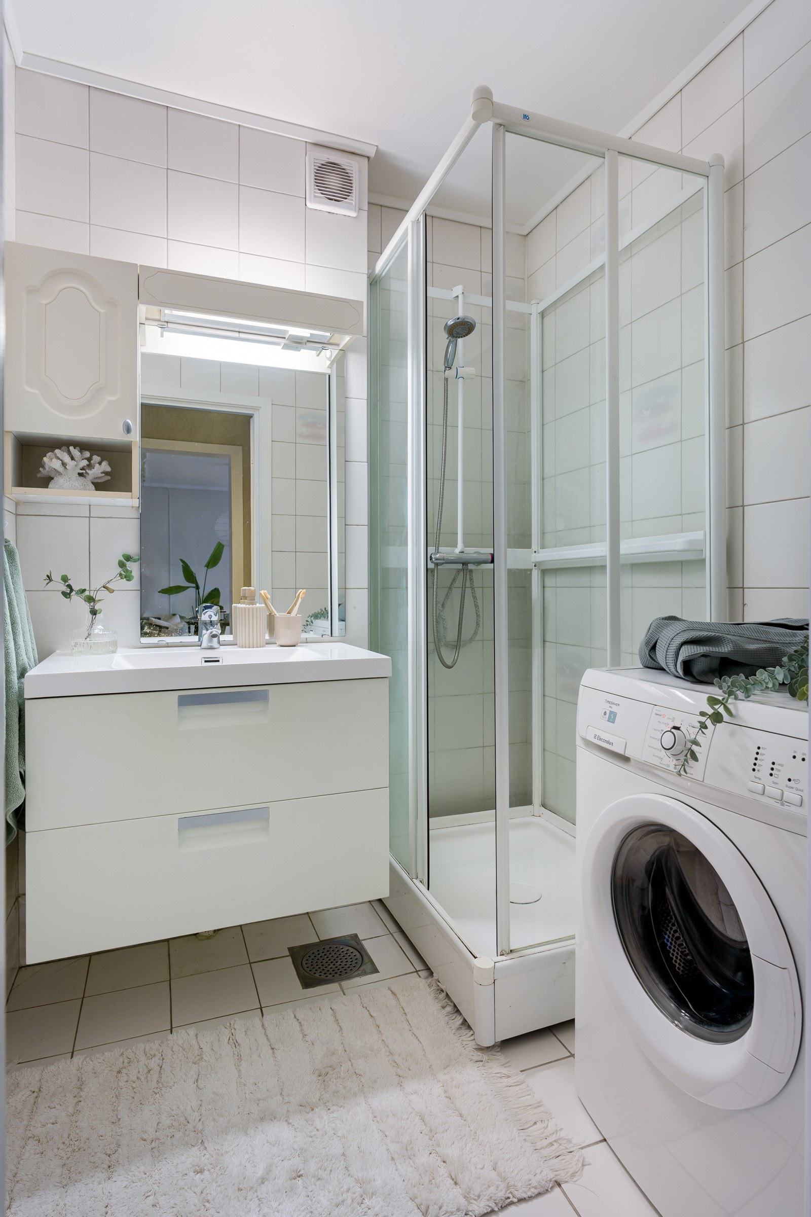 Flislagt bad med dusjkabinett og opplegg for vaskemaskin. Galleribilde