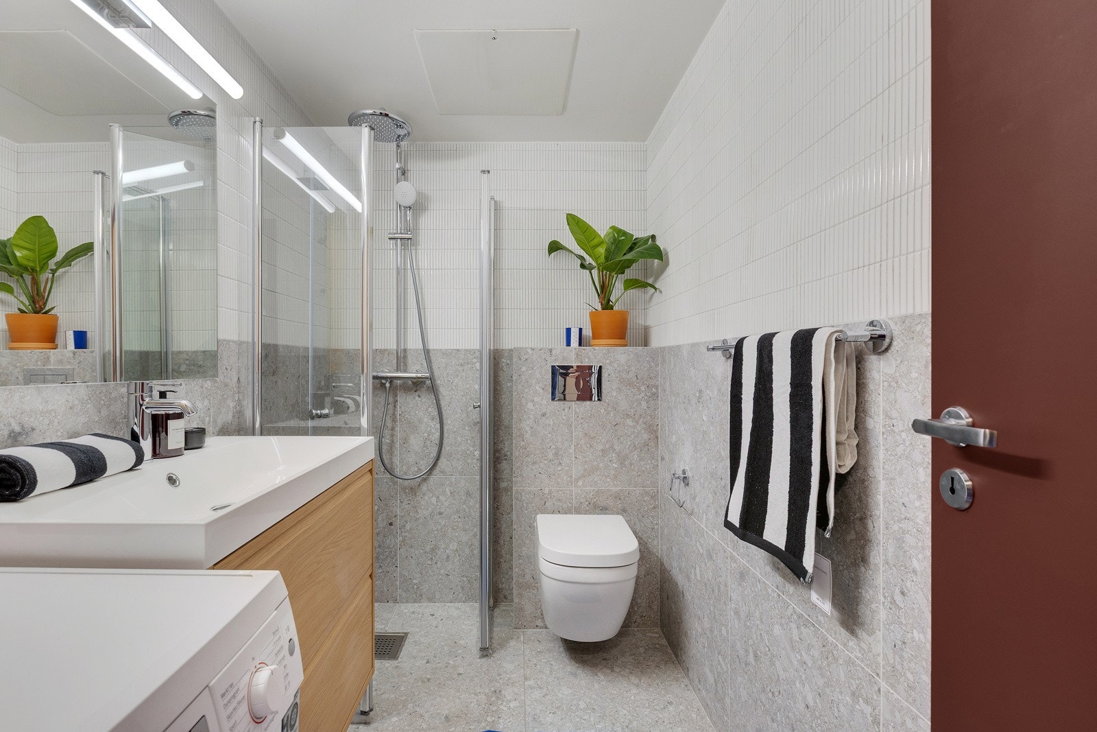 De nydelige material- og fargevalgene går også igjen på badet. Leiligheten har et svært pent, flislagt baderom som nylig ble pusset opp med nye fliser, innredning, dusjsett og toalett (mars 2025). Galleribilde