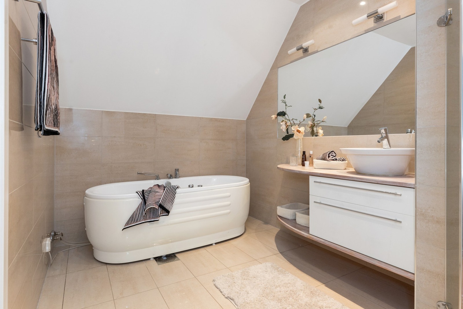 Det største badet er flislagt og inneholder både badekar, servant med underskap og dusjnisje. Galleribilde