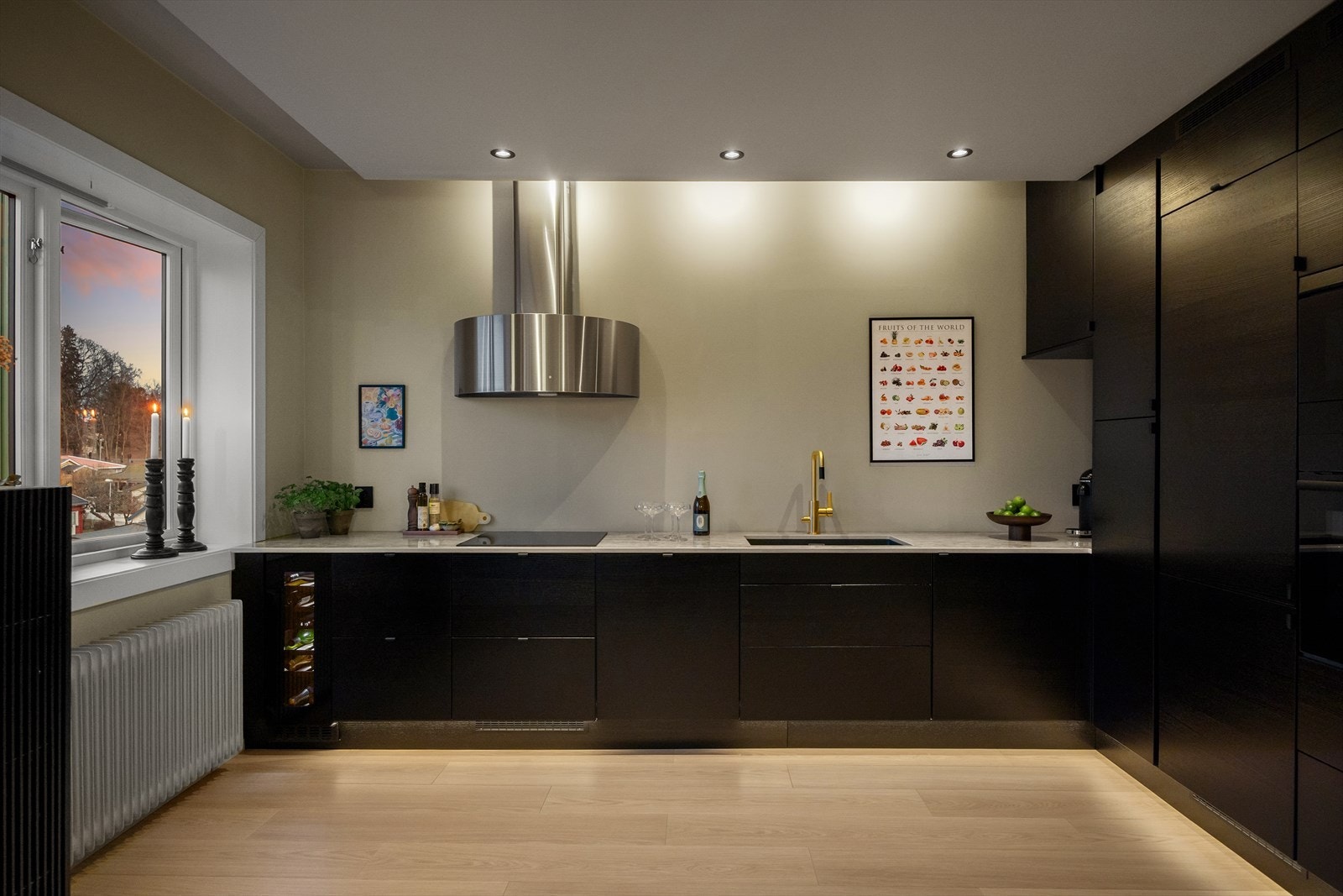 Med delikat belysning og moderne løsninger fremstår kjøkkenet som et stilfullt hjerte i hjemmet, selv på kvelden. Galleribilde