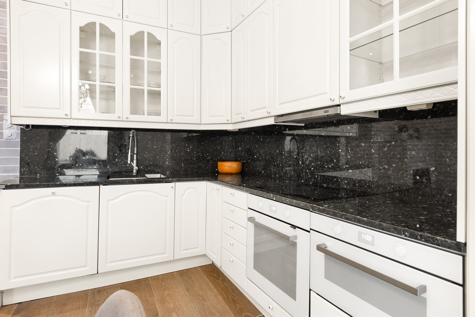 Flott klassisk kjøkkeninnredning bestående av skapdører med profilerte fronter og benkeplate i stein. Galleribilde