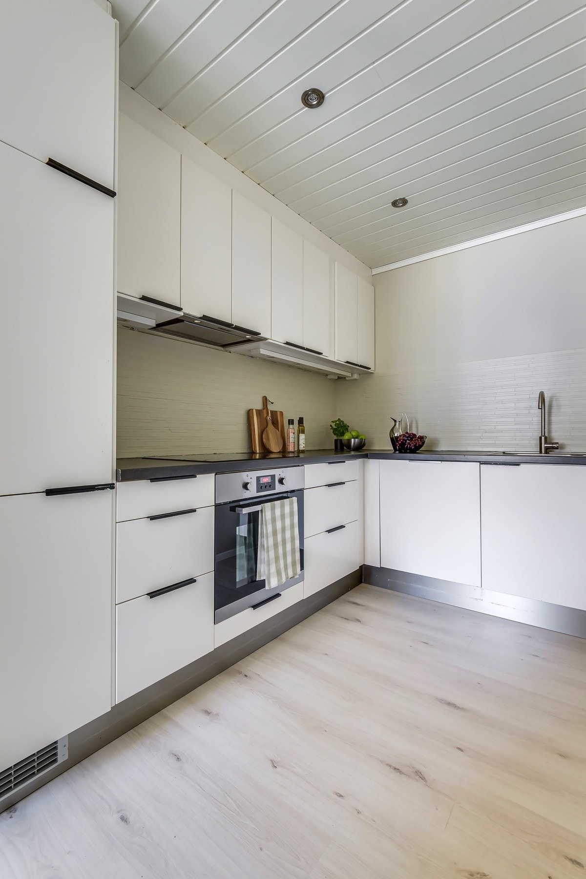 Lekkert kjøkken med spotter i tak og lys under kjøkkenskap. Galleribilde