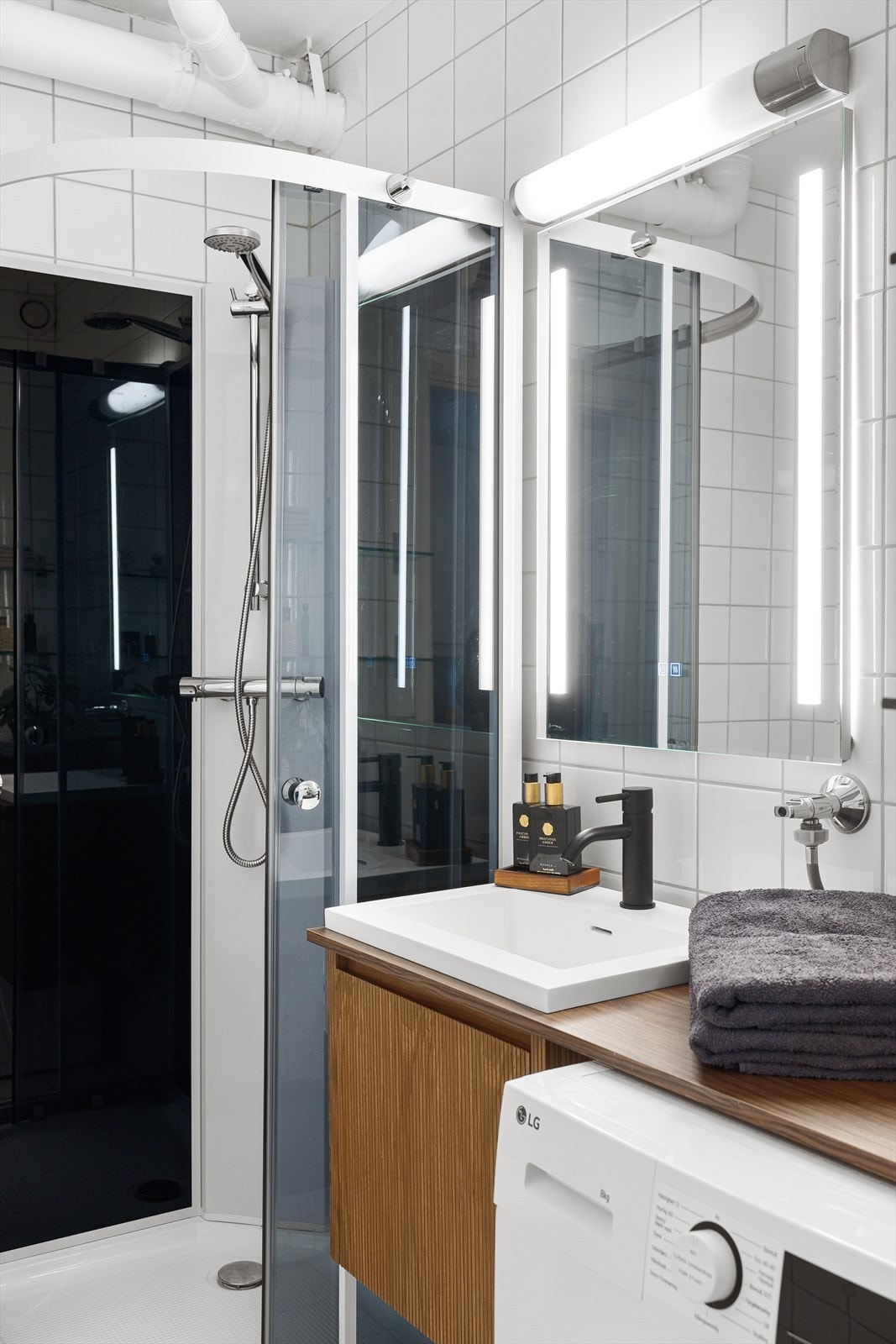 Speil med sidelys og overlys med stikkontakt på vegg over servant. Galleribilde