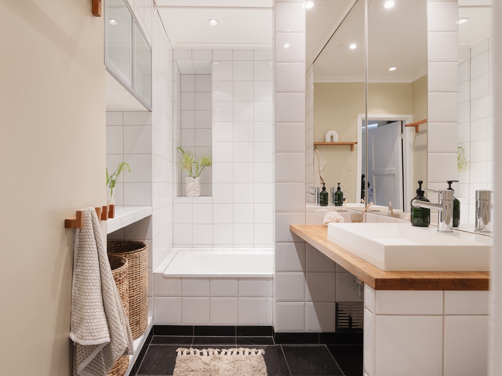 Leilighetens bad ligger lett tilgjengelig mellom stue og kjøkken. Badet er fra 2006 med fliser og heltre benkeplate. Galleribilde