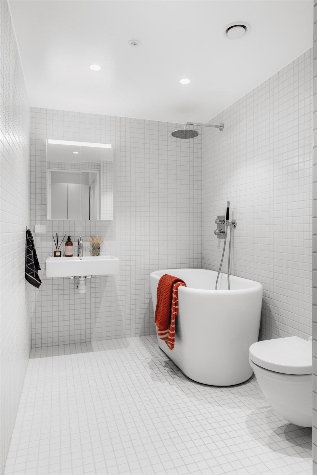 Stilrent, flislagt baderom med gulvvarme. Badet består av badekar, veggmontert klosett, servant og speilskap. Galleribilde