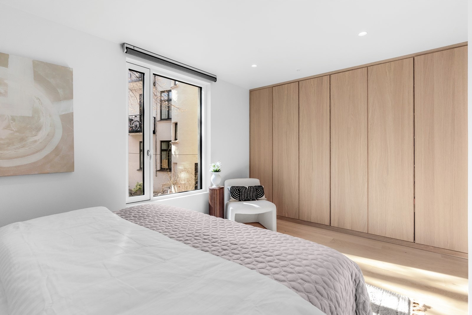 Soverommet byr på rikelig med oppbevaring i et romslig garderobeskap med elegante eikefronter som strekker seg langs hele veggen. Galleribilde