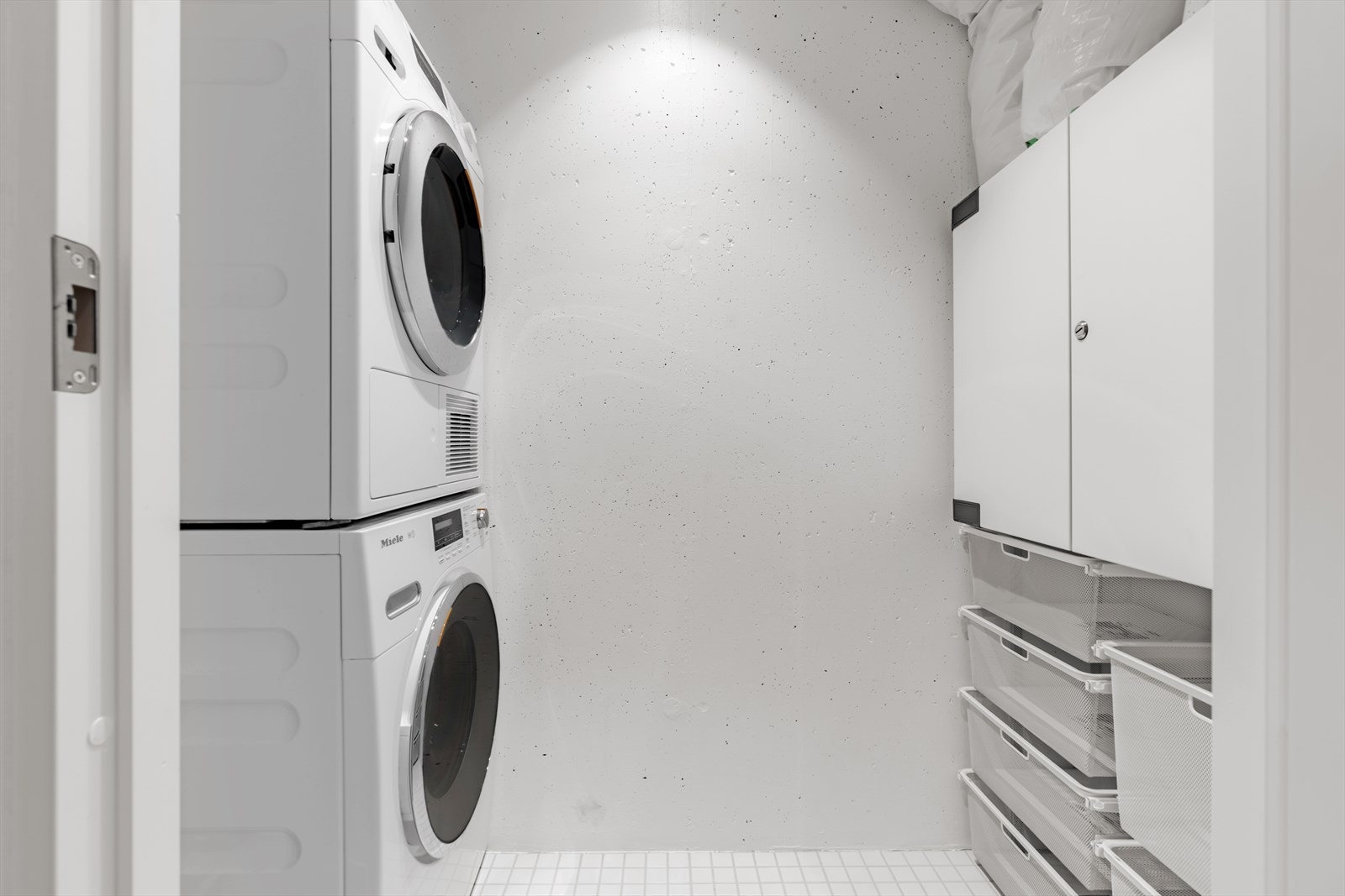 Praktisk og flislagt vaskerom med gode oppbevaringsmuligheter. Rommet har opplegg for vaskemaskin, og det er lagt til rette for en effektiv arbeidsflyt. Galleribilde