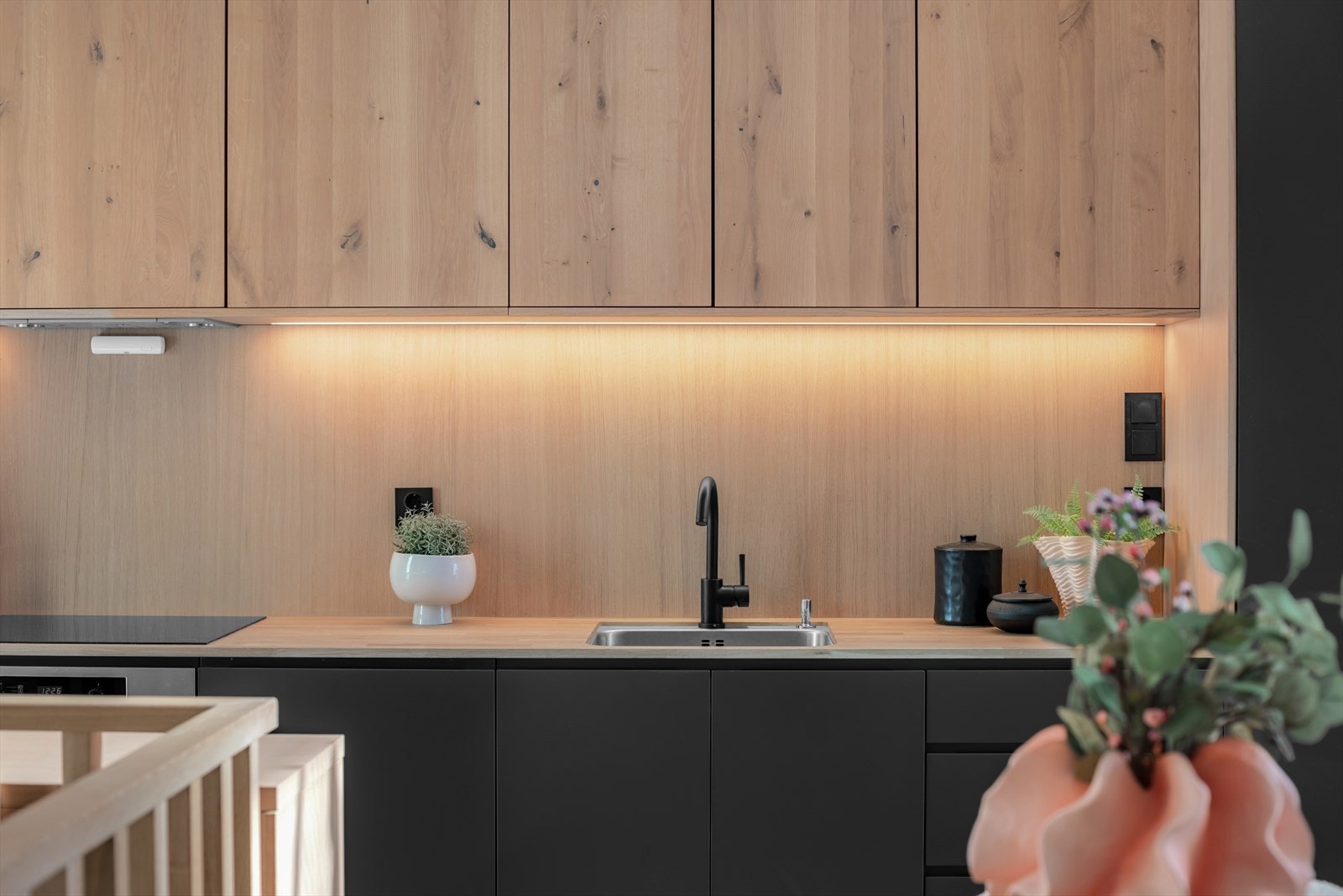 Kjøkkeninnredning med sofistikerte eike- og matte fronter som gir et tidløst uttrykk. Heltre benkeplater tilfører både varme og eksklusivitet, mens den underlimte oppvaskkummen sikrer en sømløs og praktisk arbeidsflate. Galleribilde