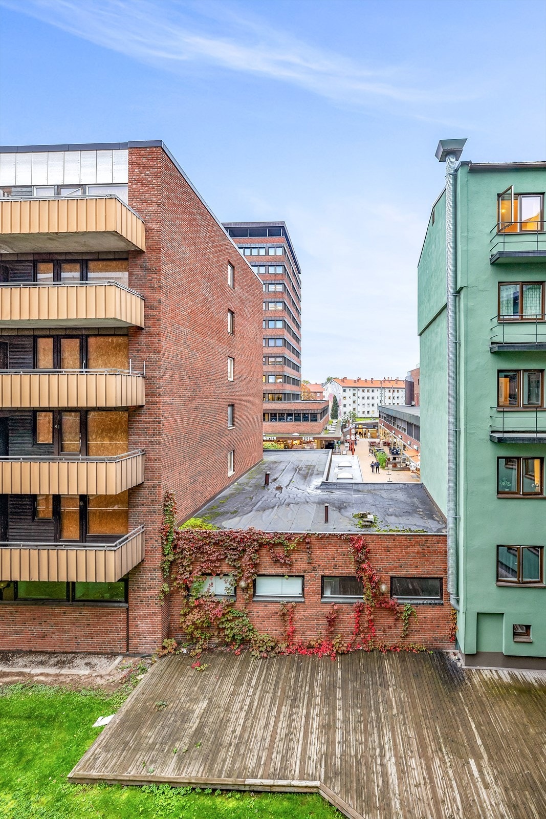 Sameiet har en hyggelig bakgård med platting, plen og møblement Galleribilde