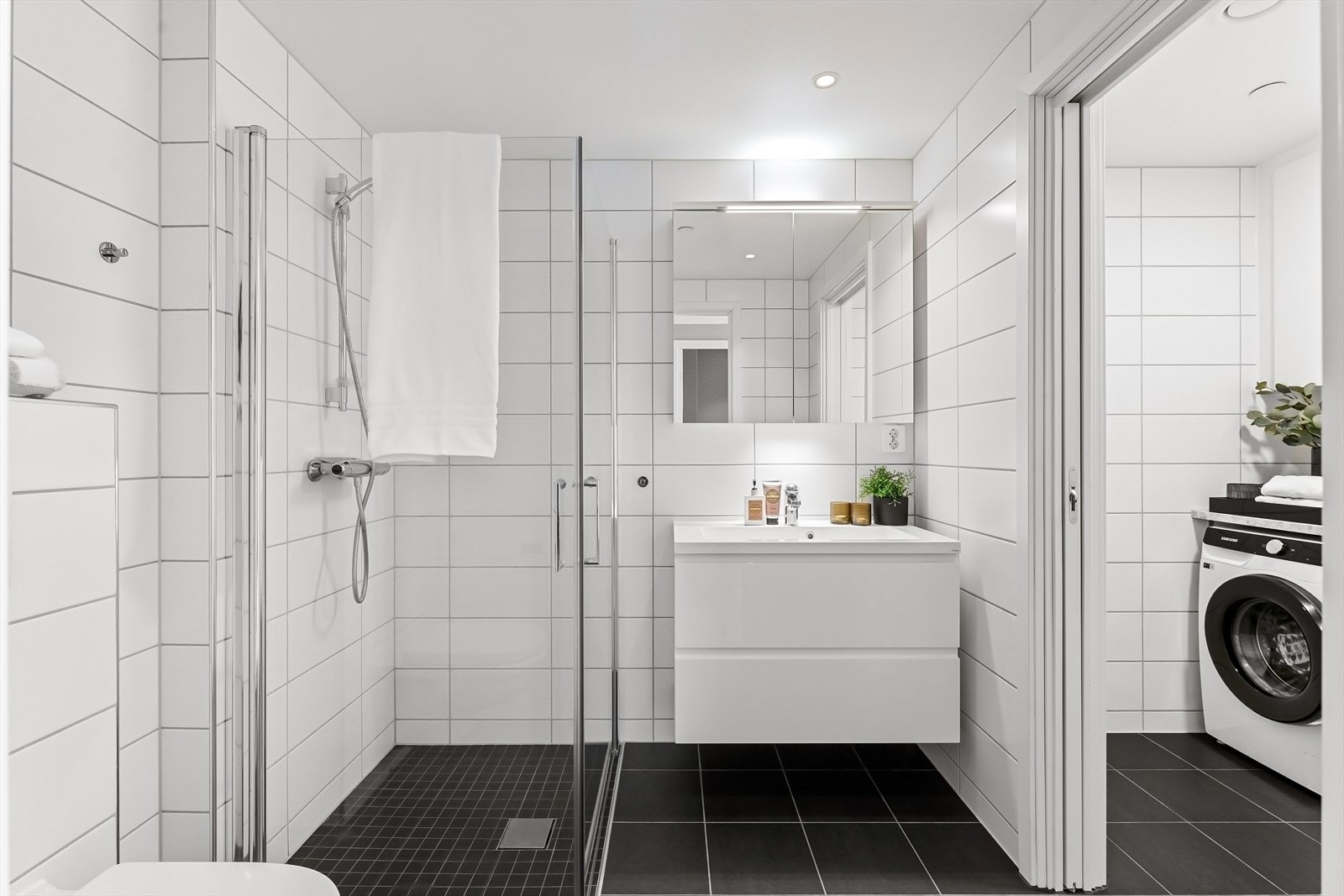 Pent opparbeidet flislagt baderom fra 2021 med adskilt vaskeromsdel. Her har du varmekabler i gulv. Rommet er innredet med vegghengt toalett og dusjsone med glassdører. Baderomsinnredning med nedfelt servant og overskap med speildører. Galleribilde