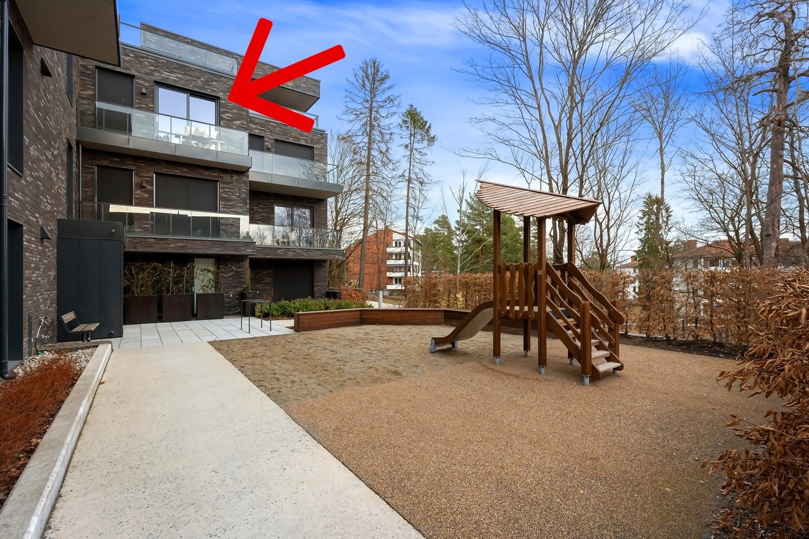 Gangsonen har polert betong. Steinsatt areal utenfor inngangspartiet. Pilen peker mot soverommene og balkong. På soverom 2 er utvendige screens kjørt ned. Galleribilde