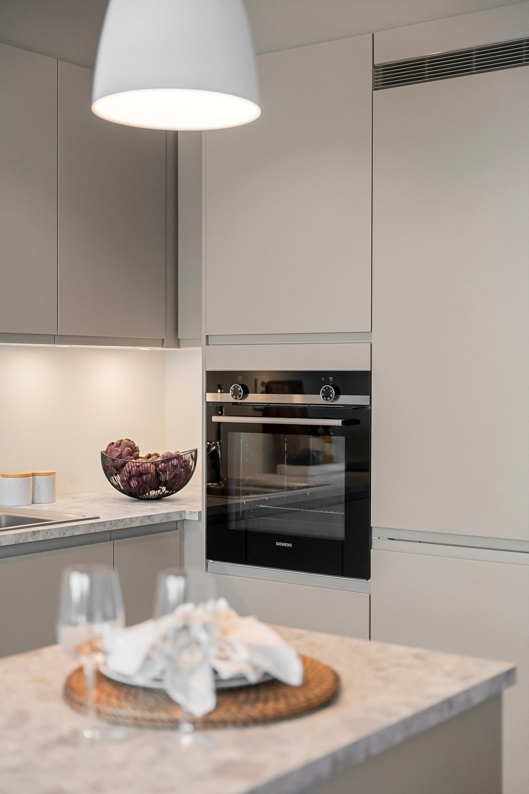 Tiltalende kjøkken med innredning fra Sigdal. Integrert stekovn, induksjonstopp og oppvaskmaskin fra Siemens. Avtrekksvifte/kjøkkenventilator fra Røroshetta. Galleribilde