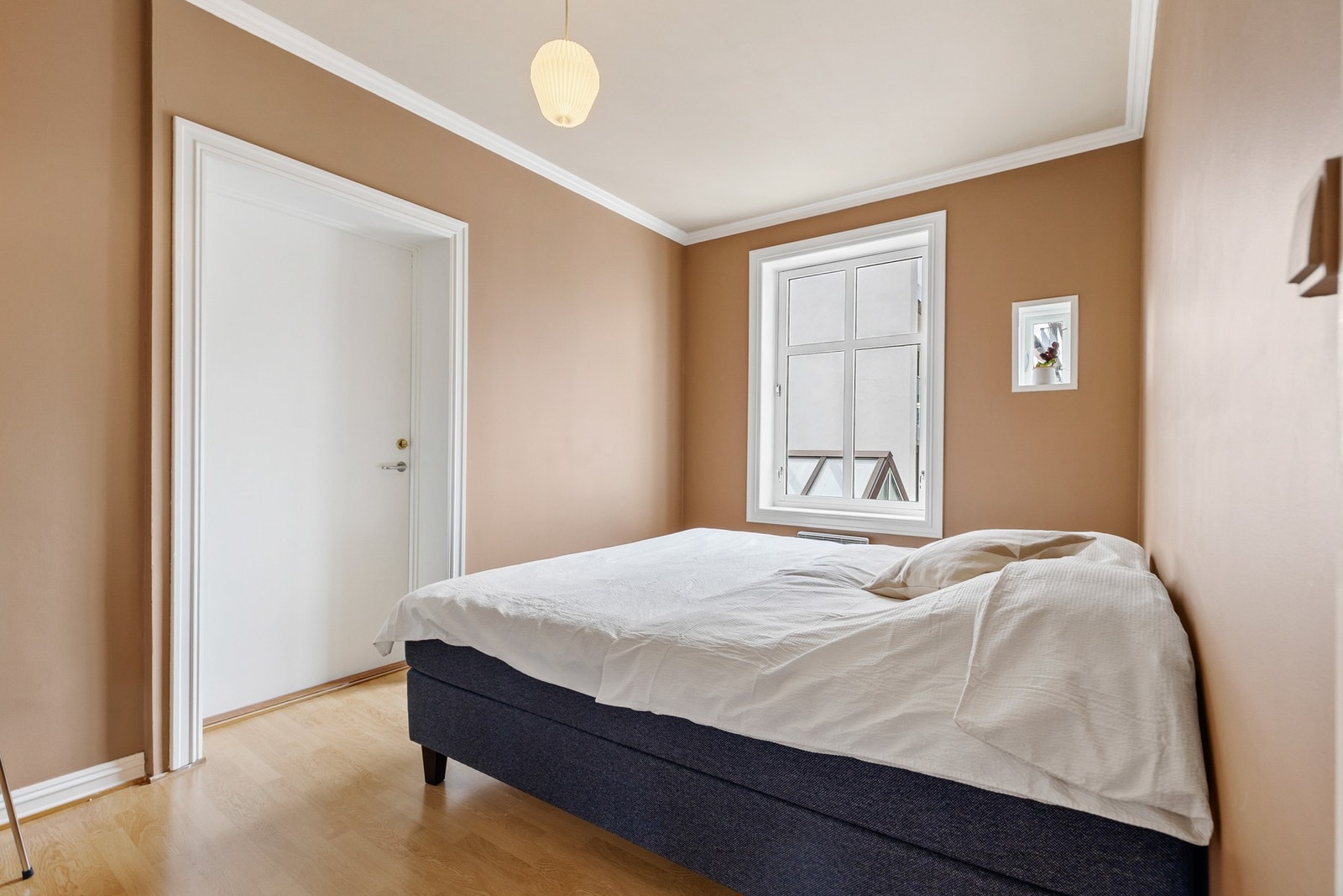 Leiligheten har to soverom, begge malt i samme moderne farge og med laminat på gulv Galleribilde