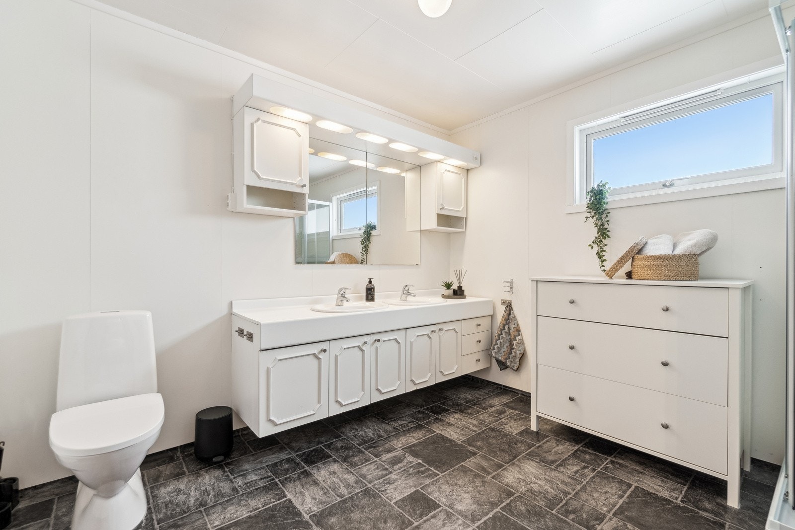 Badet i underetasjen er av svært god størrelse, og er innredet med dobbelservant med underskap, speil, toalett og dusjkabinett. Galleribilde